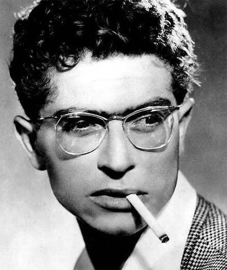 French singer, actor, musician, and comedian Darry Cowl appears here in a suit, cigarette in mouth, wearing Solamor eyeglasses.