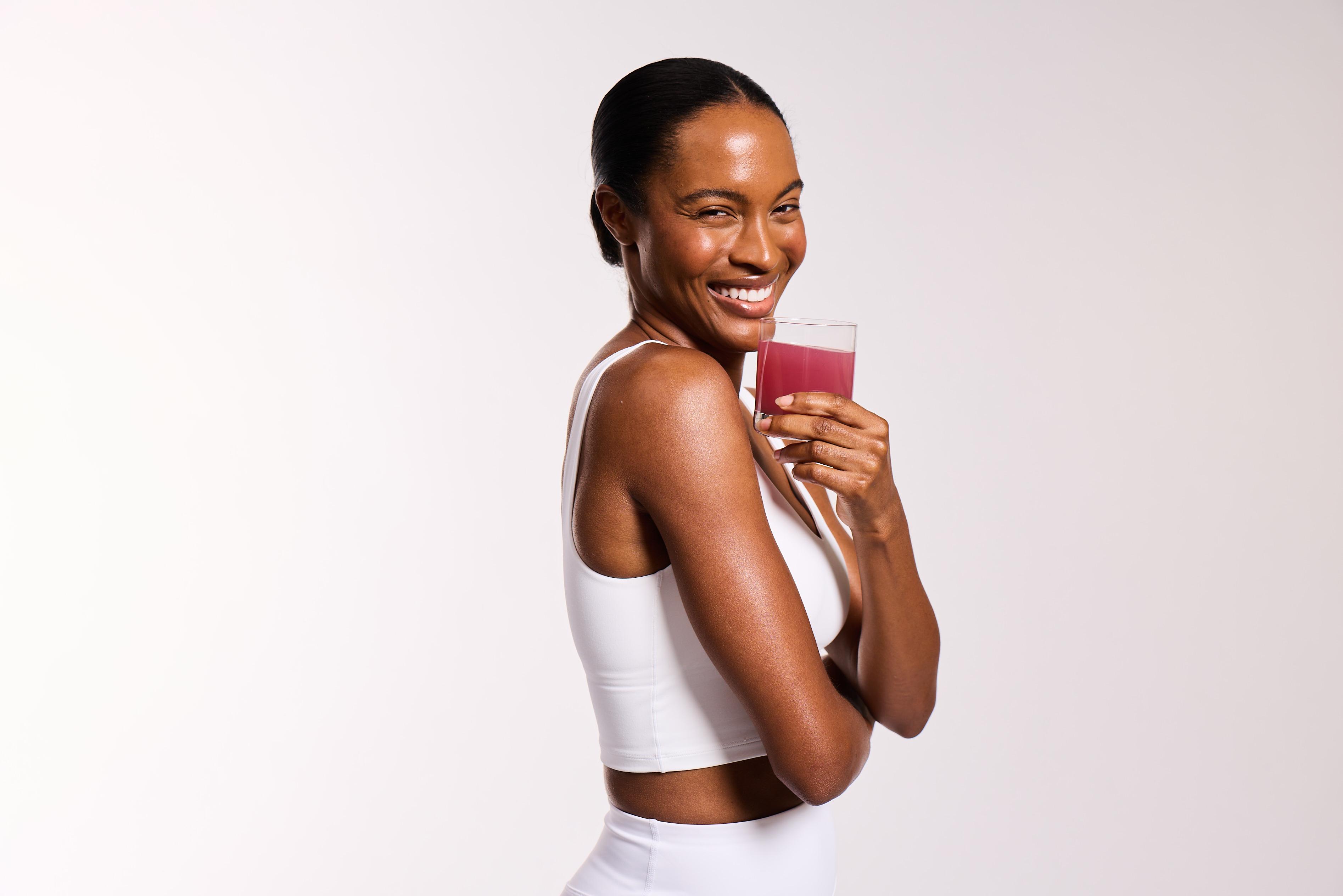 Woman smiling while drinking MAKE renewed