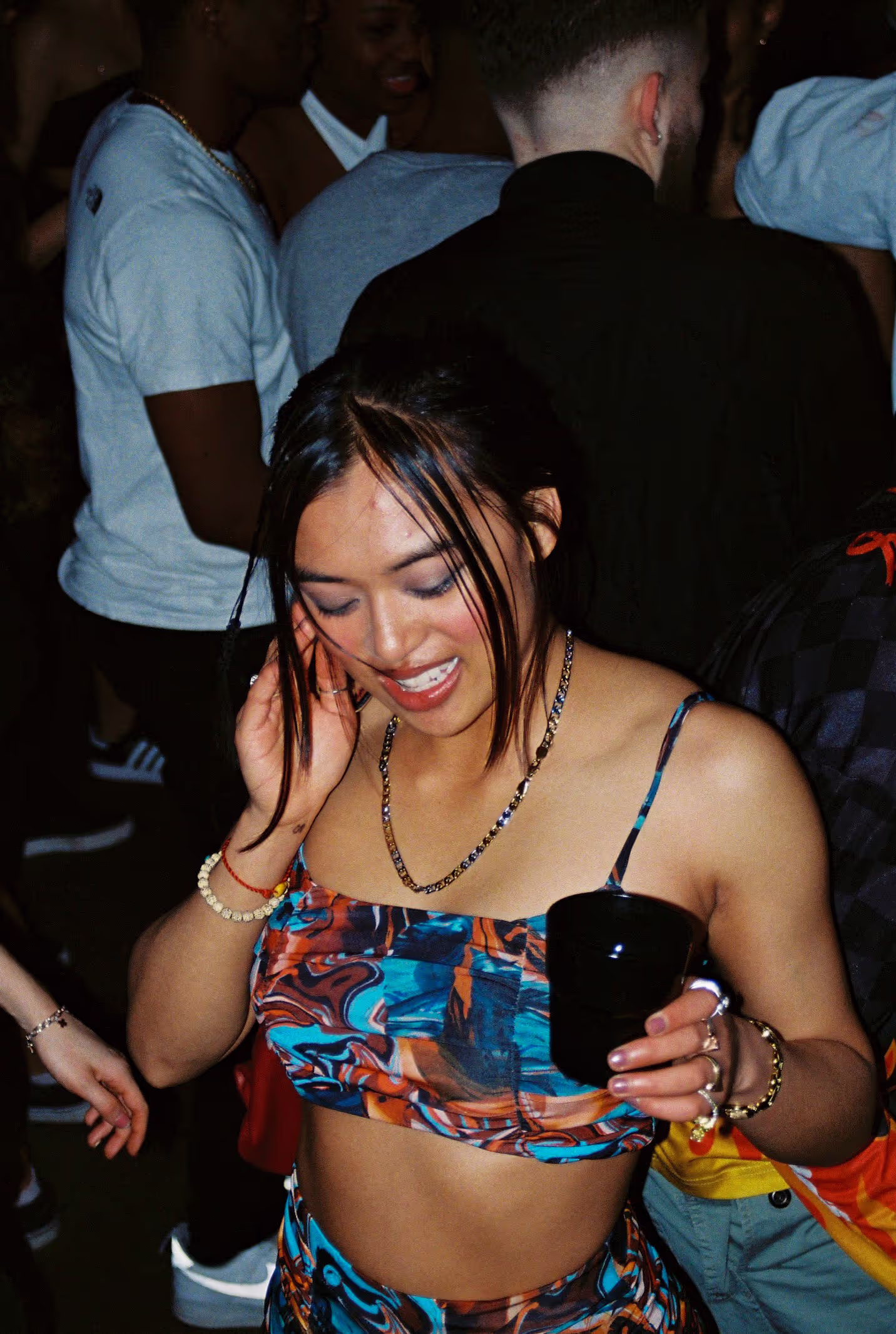 A young woman smiling and dancing at the Soirée's launch party in London, UK