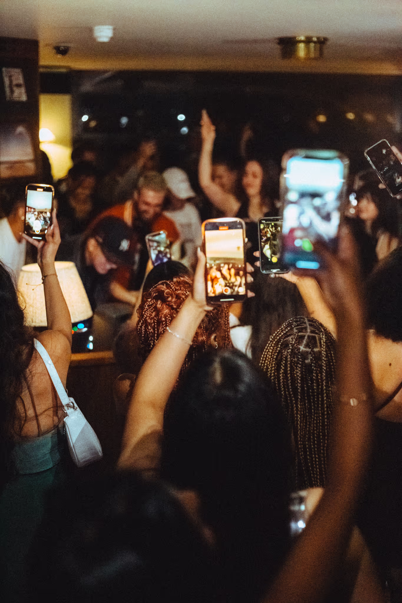 The crowd takes photos and videos at Soirée's collaboration party with Brighton Beach House in Brighton, UK