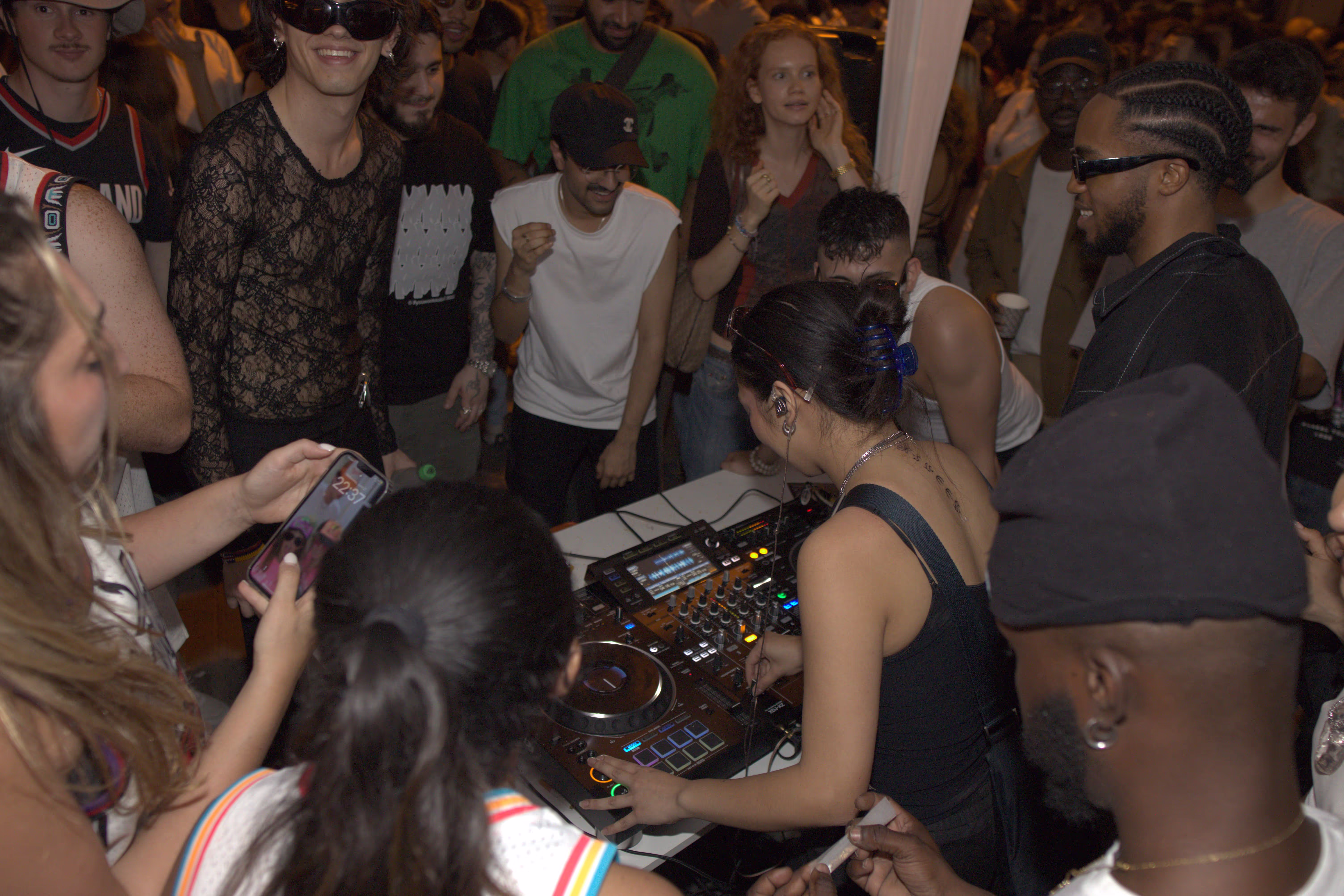 A DJ girl performing with people around dancing at Soirée's block party in Paris, France