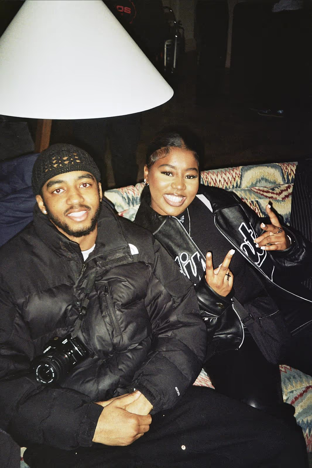 Two young people sitting on a sofa and smiling at the art show by Soirée at Soho Brighton Beach, UK