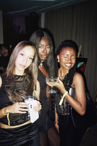 Three young women are having fun at the art show by Soirée at Soho Brighton Beach, UK