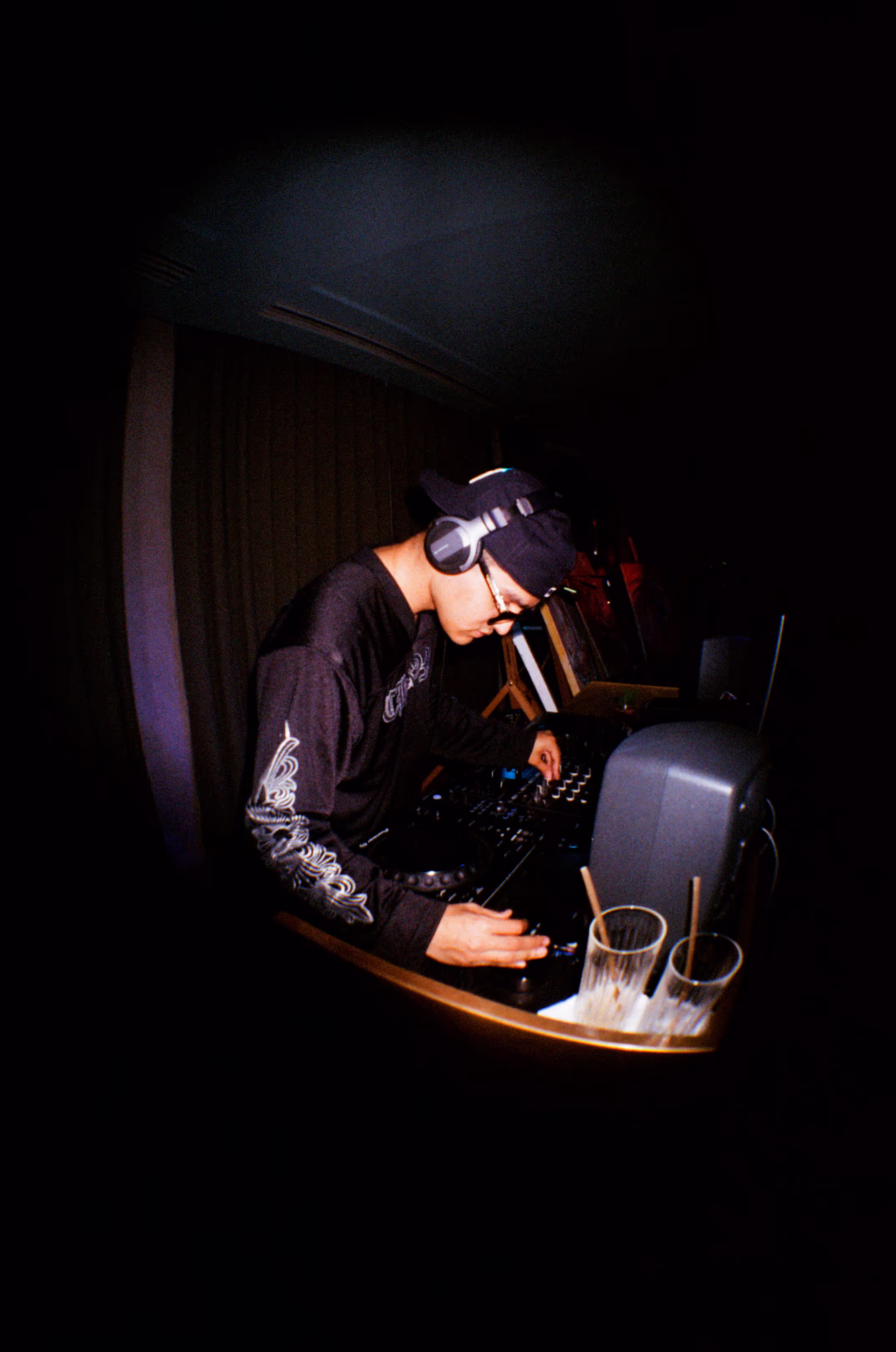 A focused DJ performing his set at the Soirée art show and music event at Soho Brighton Beach House, Brighton, UK