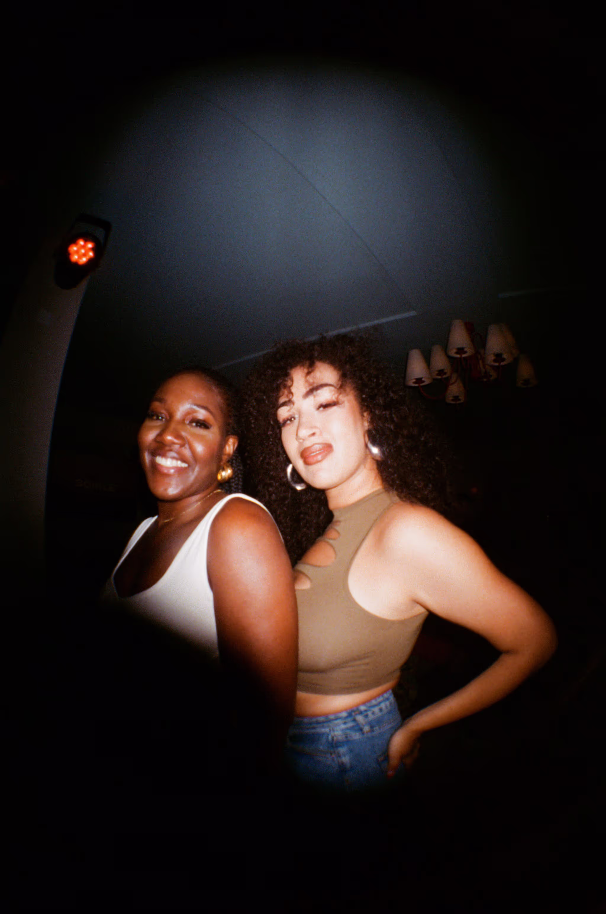 Two girlfriends posing and having fun at the Soirée art show and music event at Soho Brighton Beach House, Brighton, UK