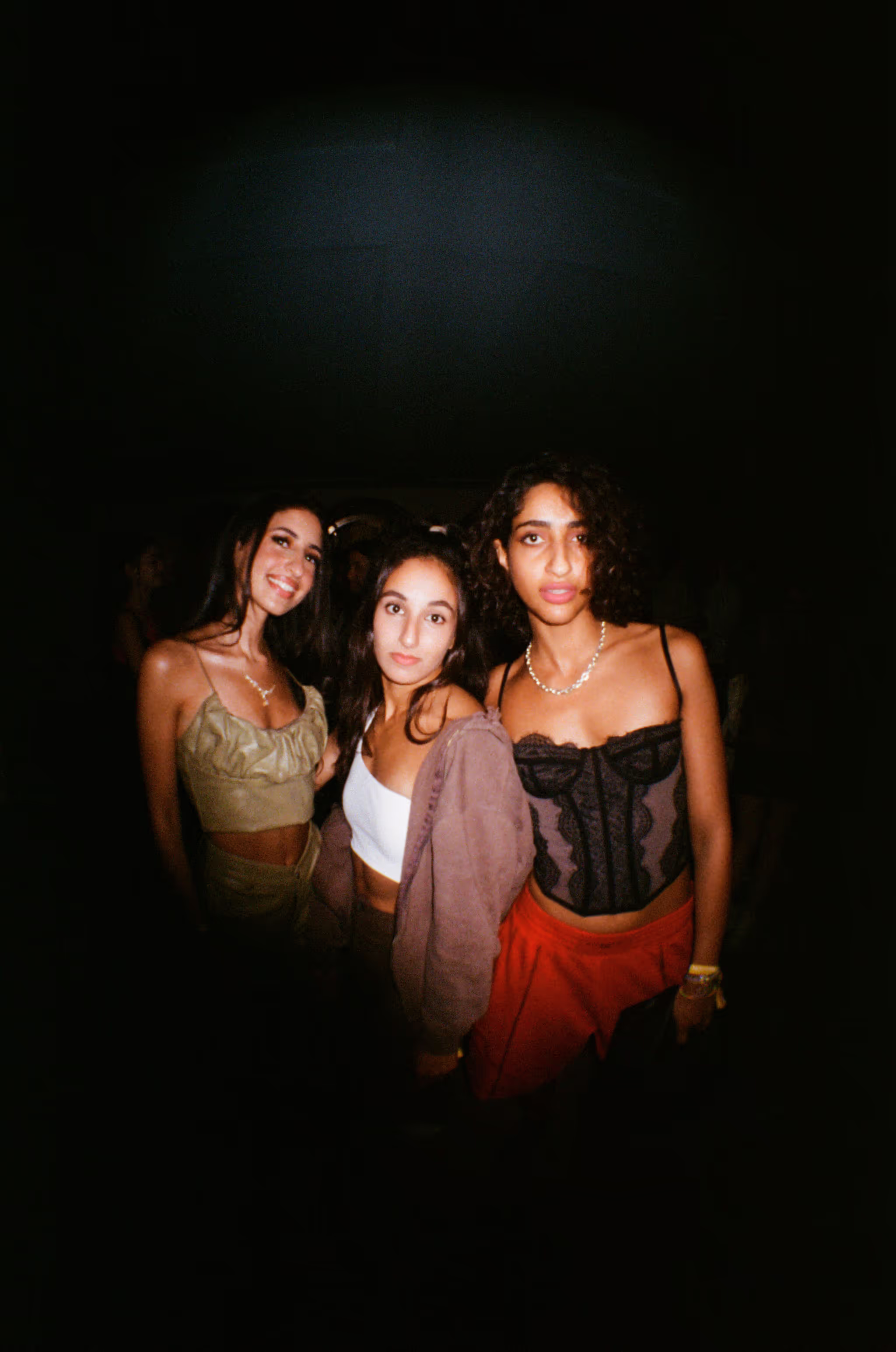 Three young women in a modern outfit posing at the Soirée art show and music event at Soho Brighton Beach House, Brighton, UK