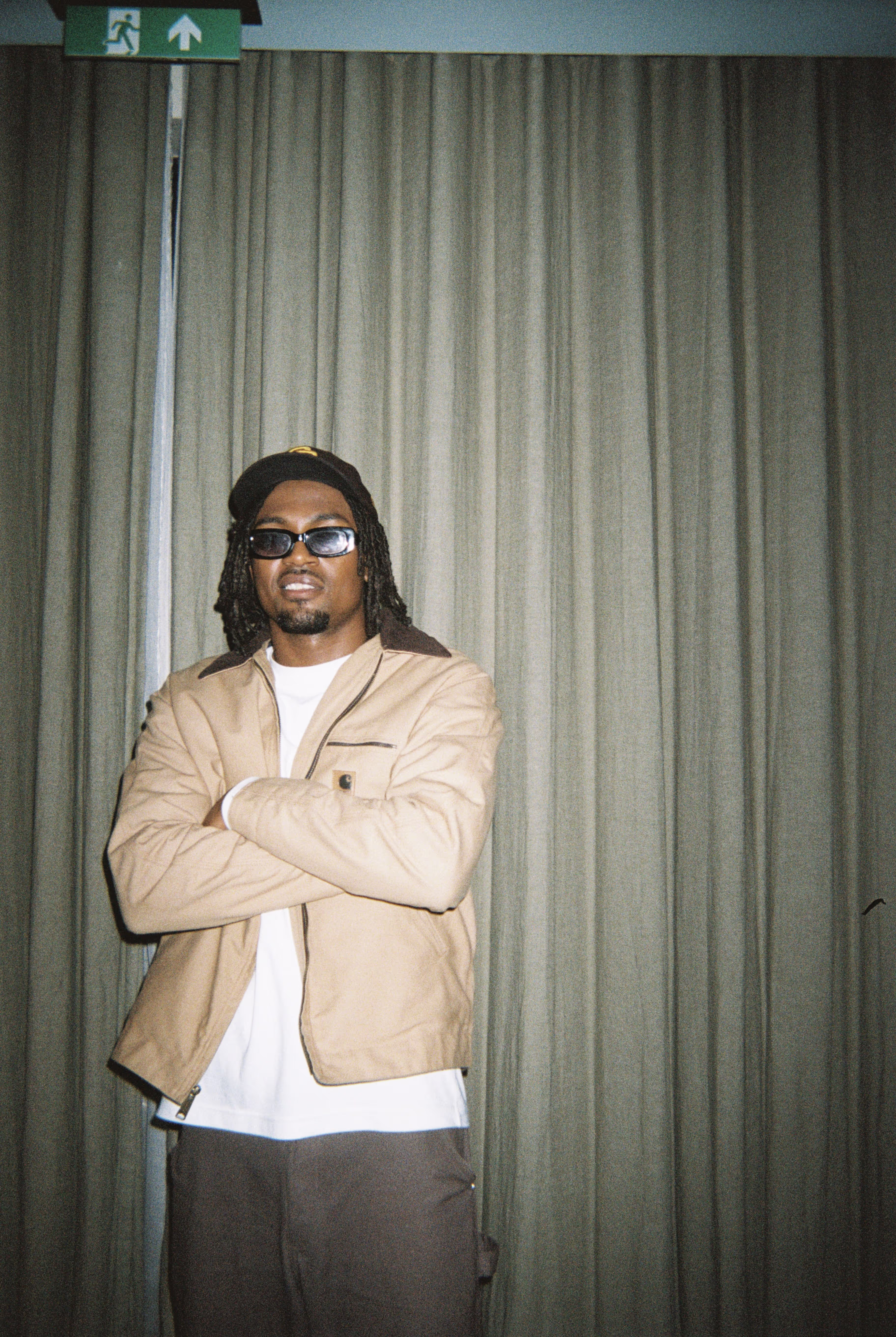A young man with glasses and crossed hands posing at the Soirée's event in Brighton, UK