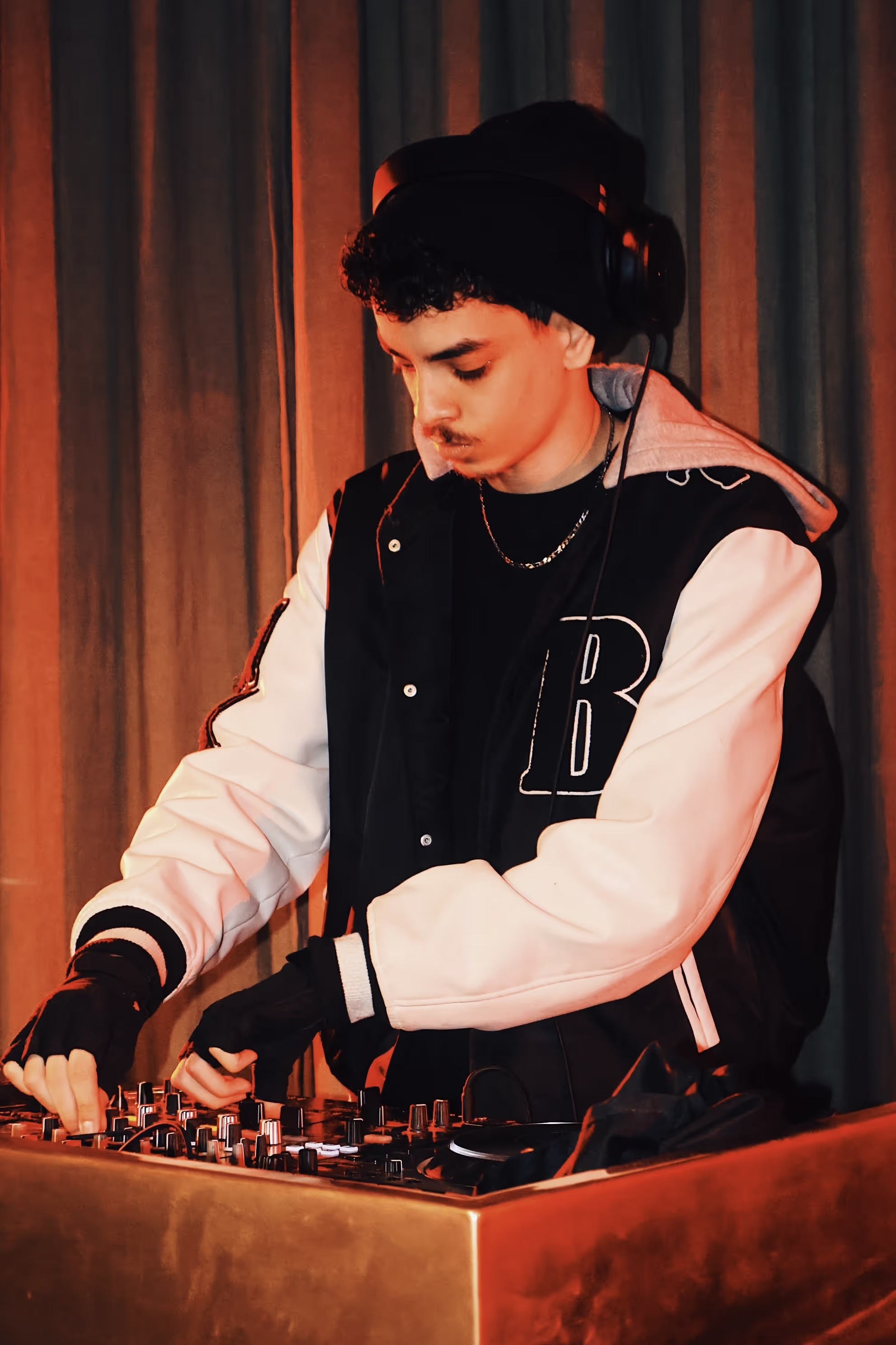 A young DJ at the DJ deck playing his set at the Soirée & GRADUATION Records collaboration event at Beach House, Brighton, UK