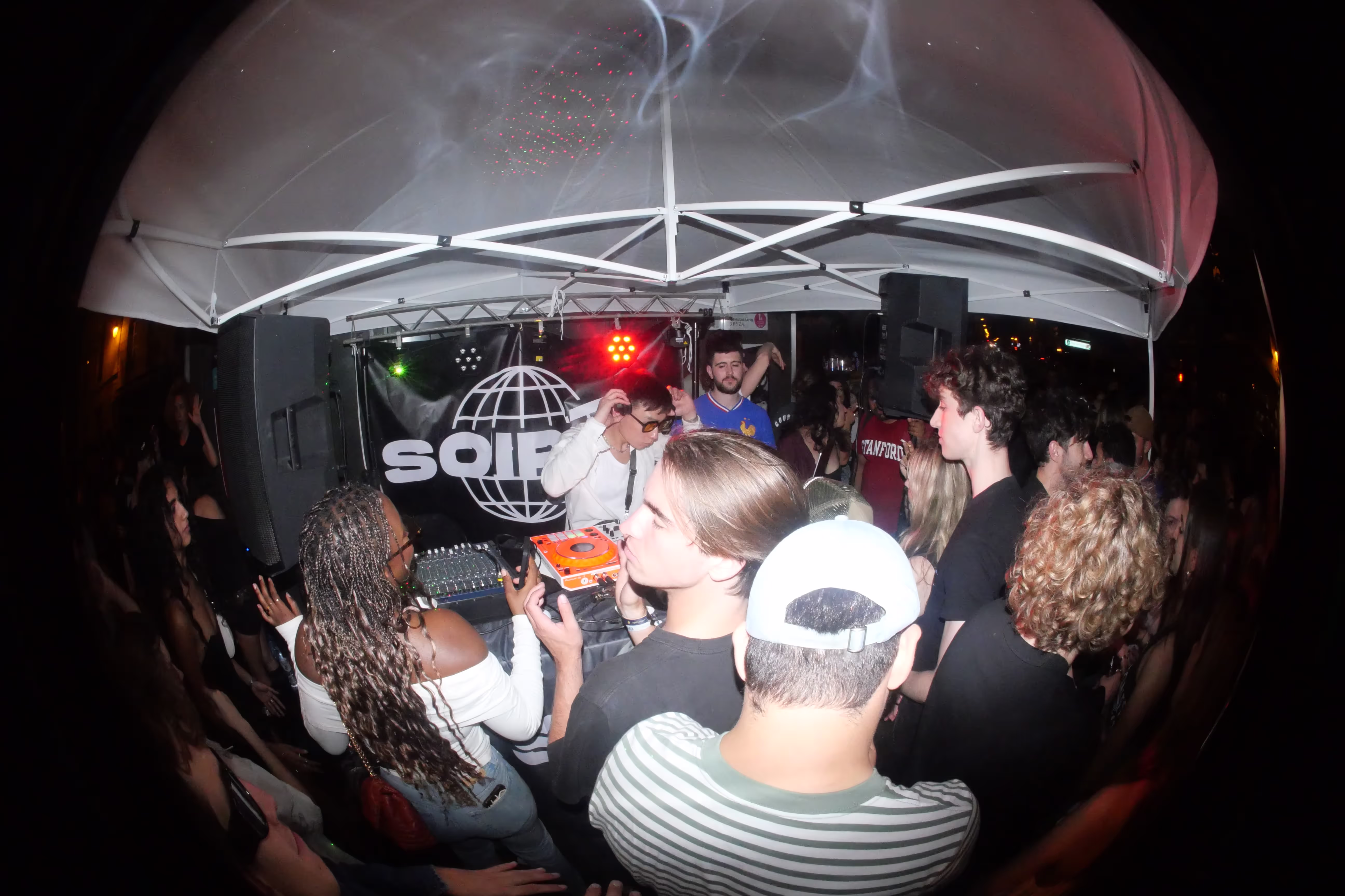 A fish-eye photo of a crowd in front of the DJ at the Soirée's party at Paris Fashion Week 2024