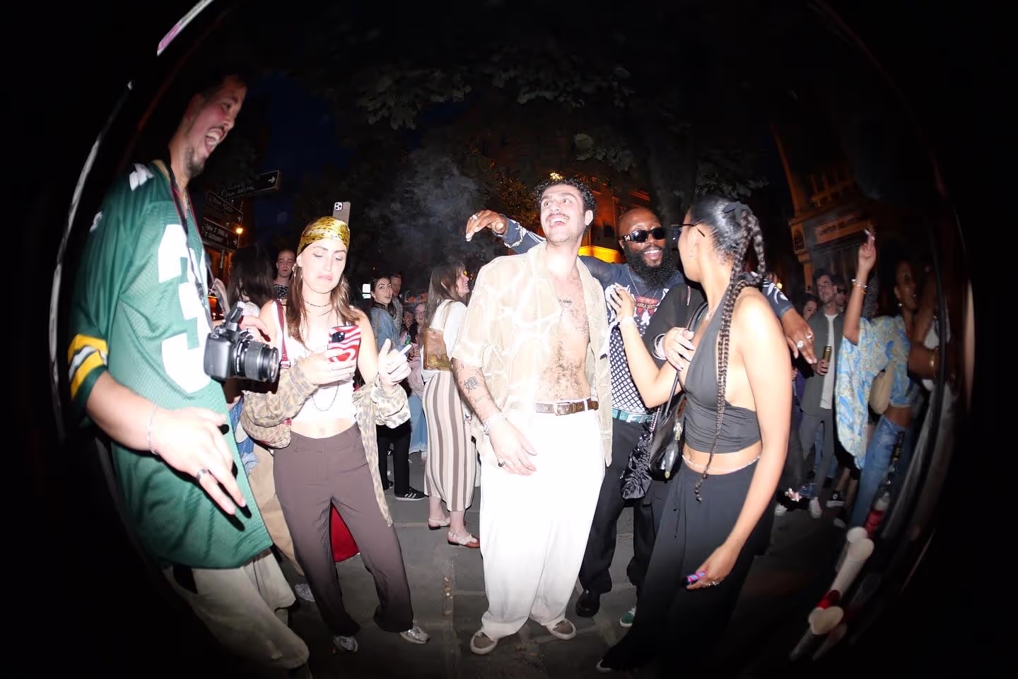 A fish-eye photo of a crowd of people having fun at Soirée's party at Paris Fashion Week 2024