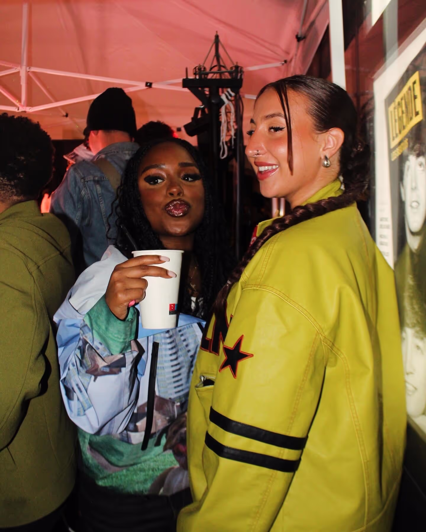 Two friends posing with a crowd in the background at a Soirée's party at Paris Fashion Week 2024