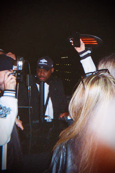 Crowd taking a photo of a DJ playing music at a rooftop party by Soirée in London, UK