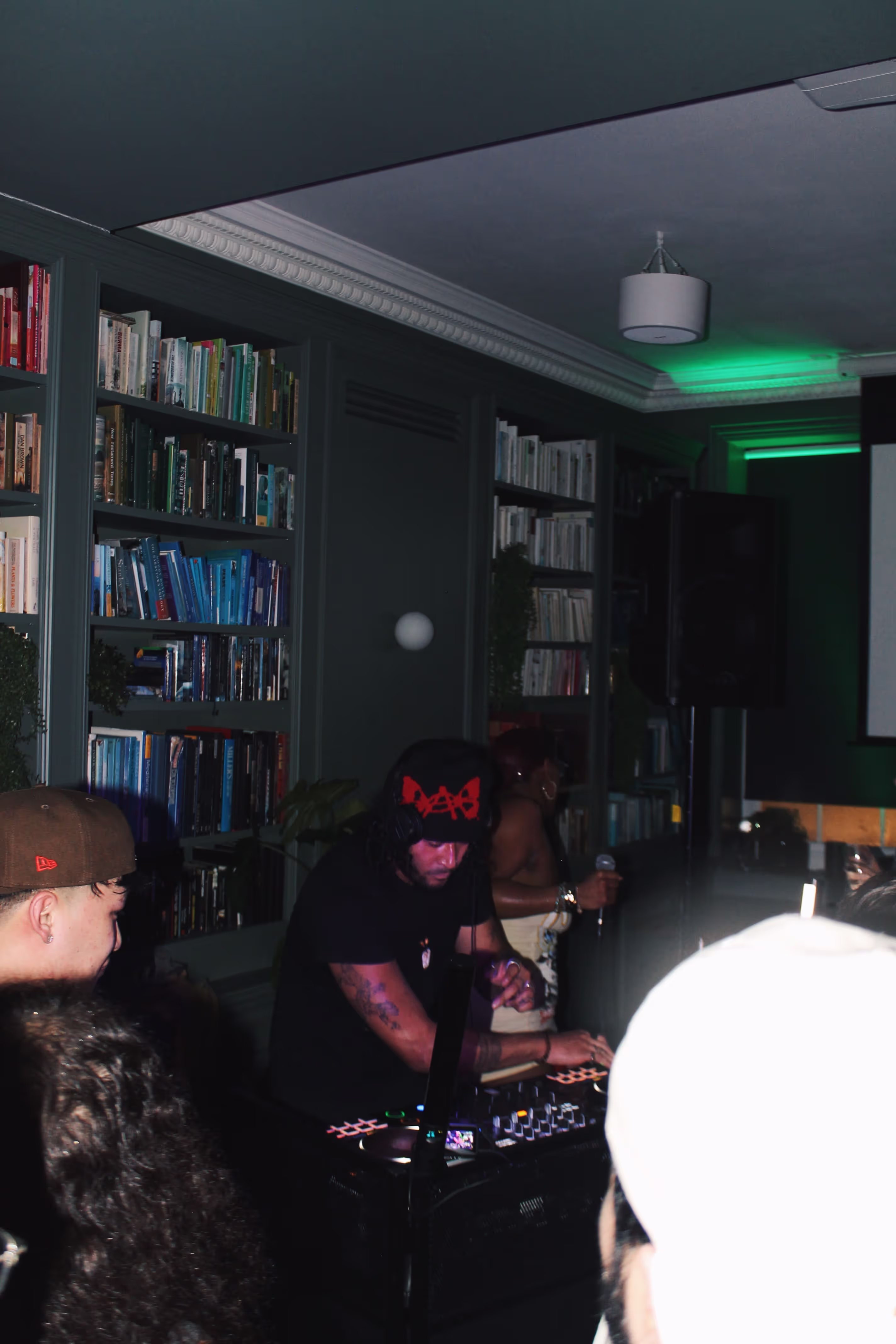 A young DJ playing music at a collaboration party by Soirée, Doppelgängers, and Serene Collective at the library in London, UK