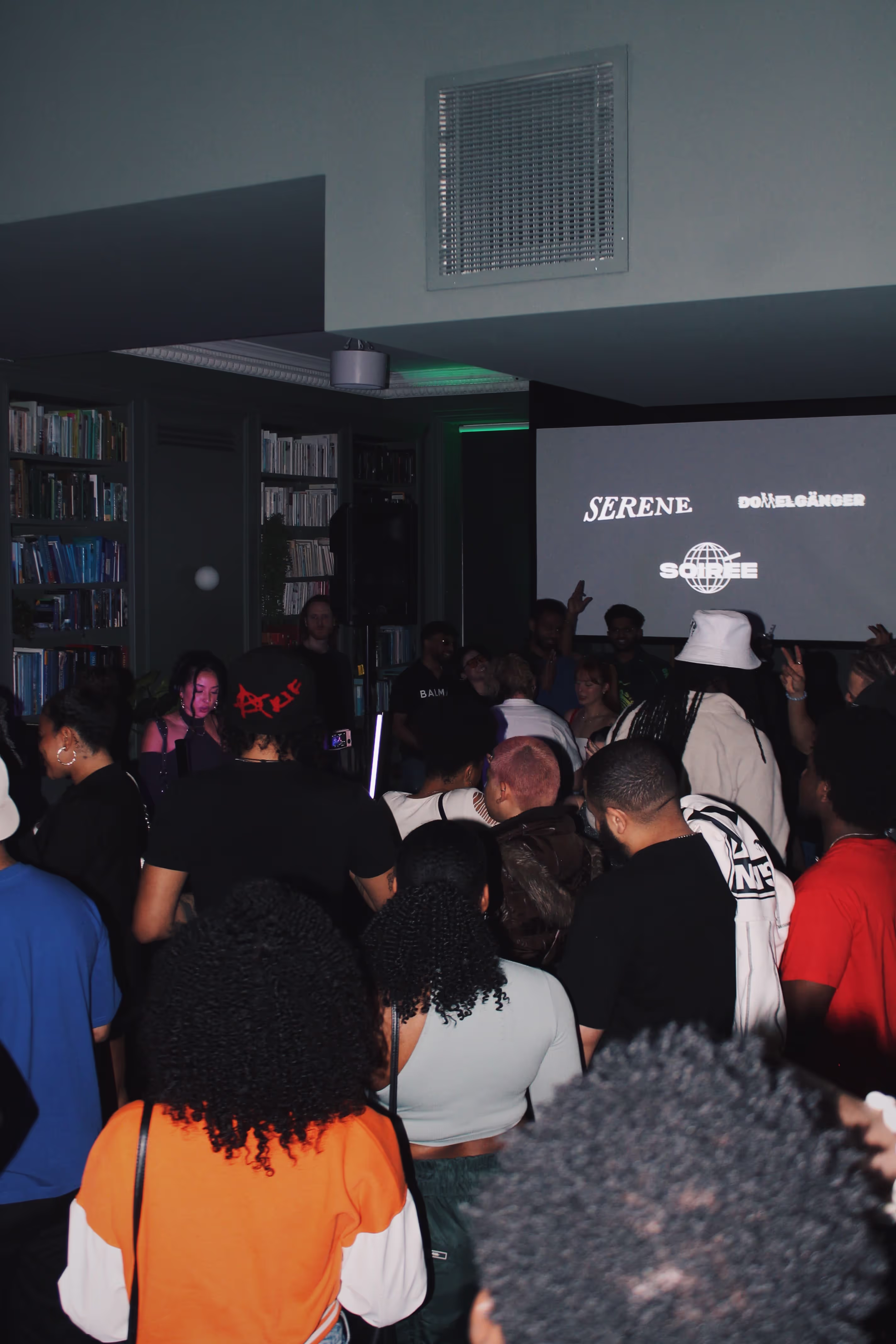 People dance at a party at a collaboration party by Soirée, Doppelgängers, and Serene Collective at the library in London, UK