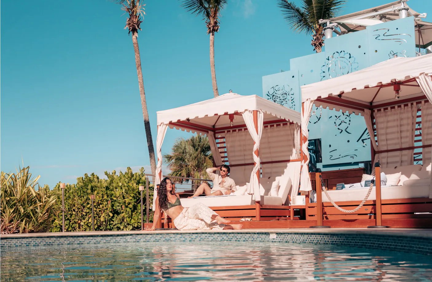 Guests relaxing by the pool cabanas at Wyndham Grand Rio Mar