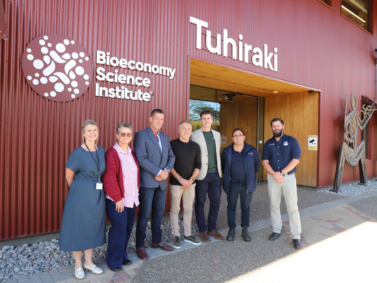 Seven people standing outside the Bioeconomy Science Institute building named Tuhiraki.
