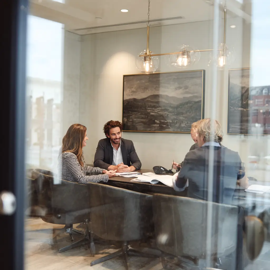 Licensed private investigators meeting with clients in professional conference room to discuss case strategy and updates