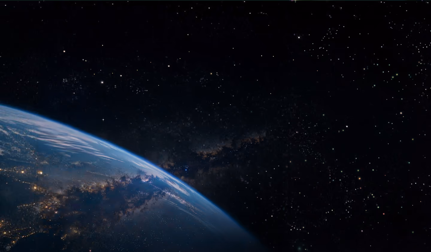 View of Earth from space showing a curved horizon with illuminated city lights and a star-filled galaxy in the background.
