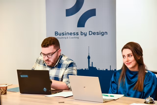 Consultants from Business by Design working together during a team meeting