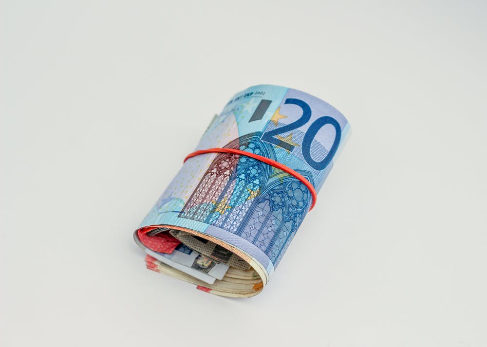 A roll of cash bills||Lots of different currencies in cash