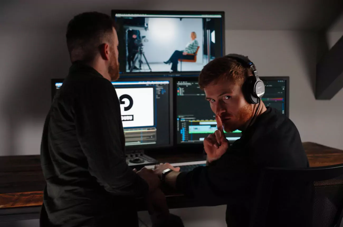 GNG Studios post-production team editing video content, with dual monitors showing footage and timeline software.