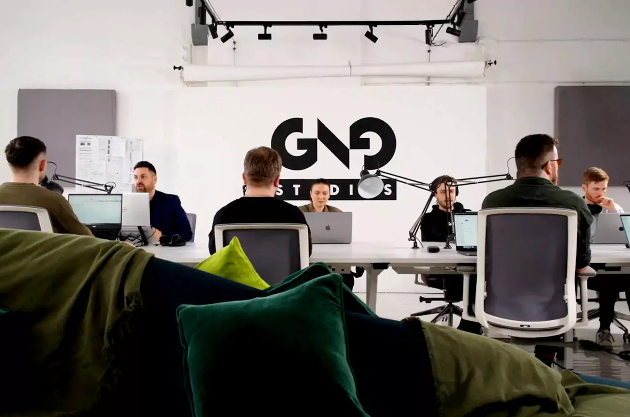 GNG Studios team collaborating during the discovery phase of a project, working together around a shared studio desk in their modern office