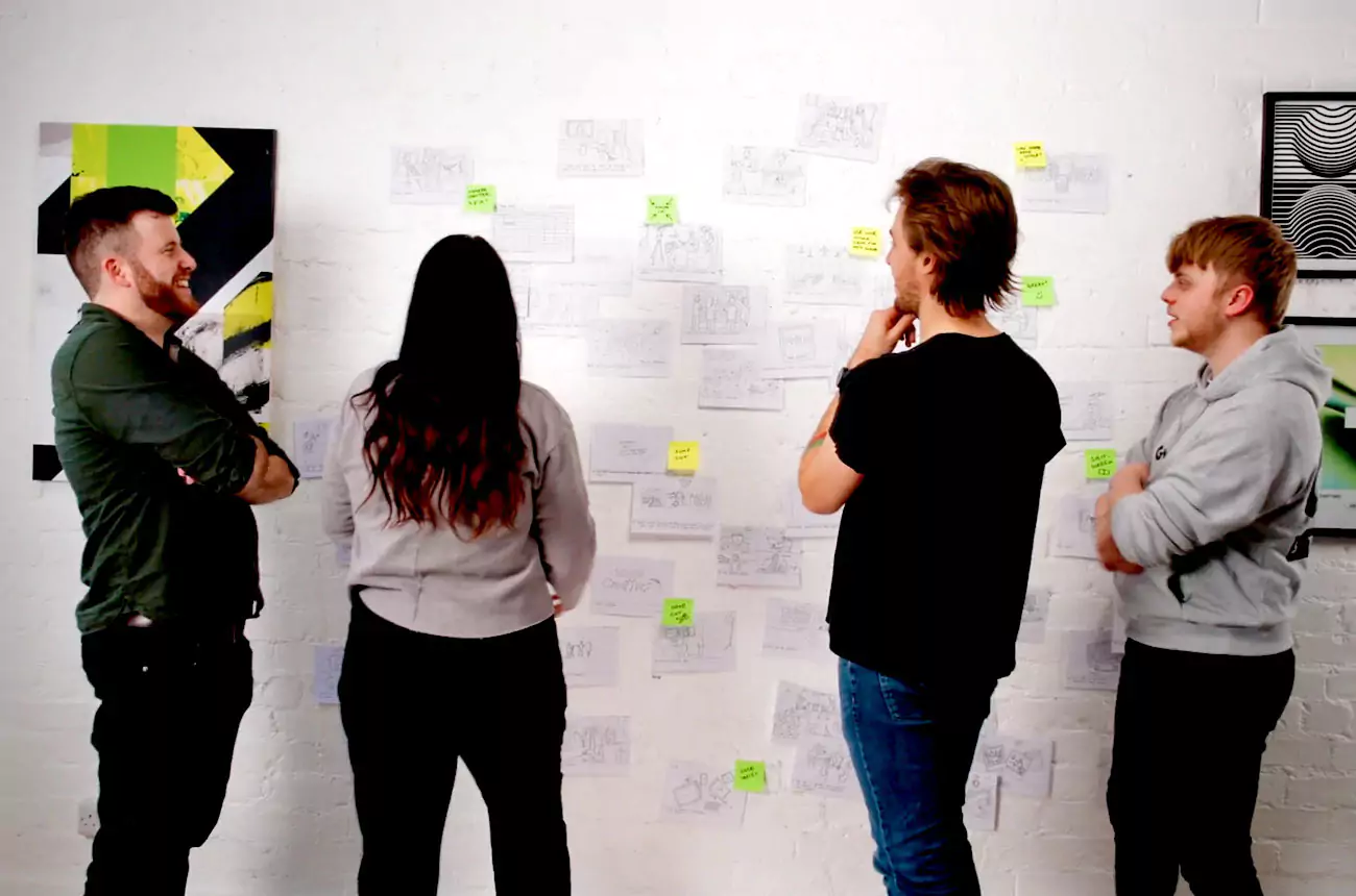 GNG Studios team reviewing and discussing storyboard ideas pinned to a wall during a pre-production planning session.