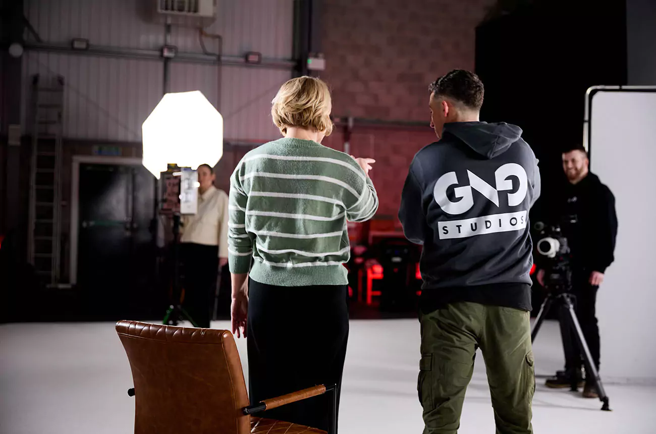 GNG Studios team directing a client on set during a studio shoot, with lighting and camera crew in place.