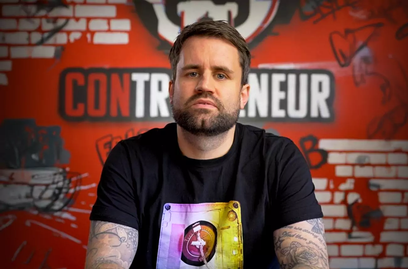 Mike Winnet in front of Contrepreneur backdrop during YouTube case study shoot, highlighting viral content strategy