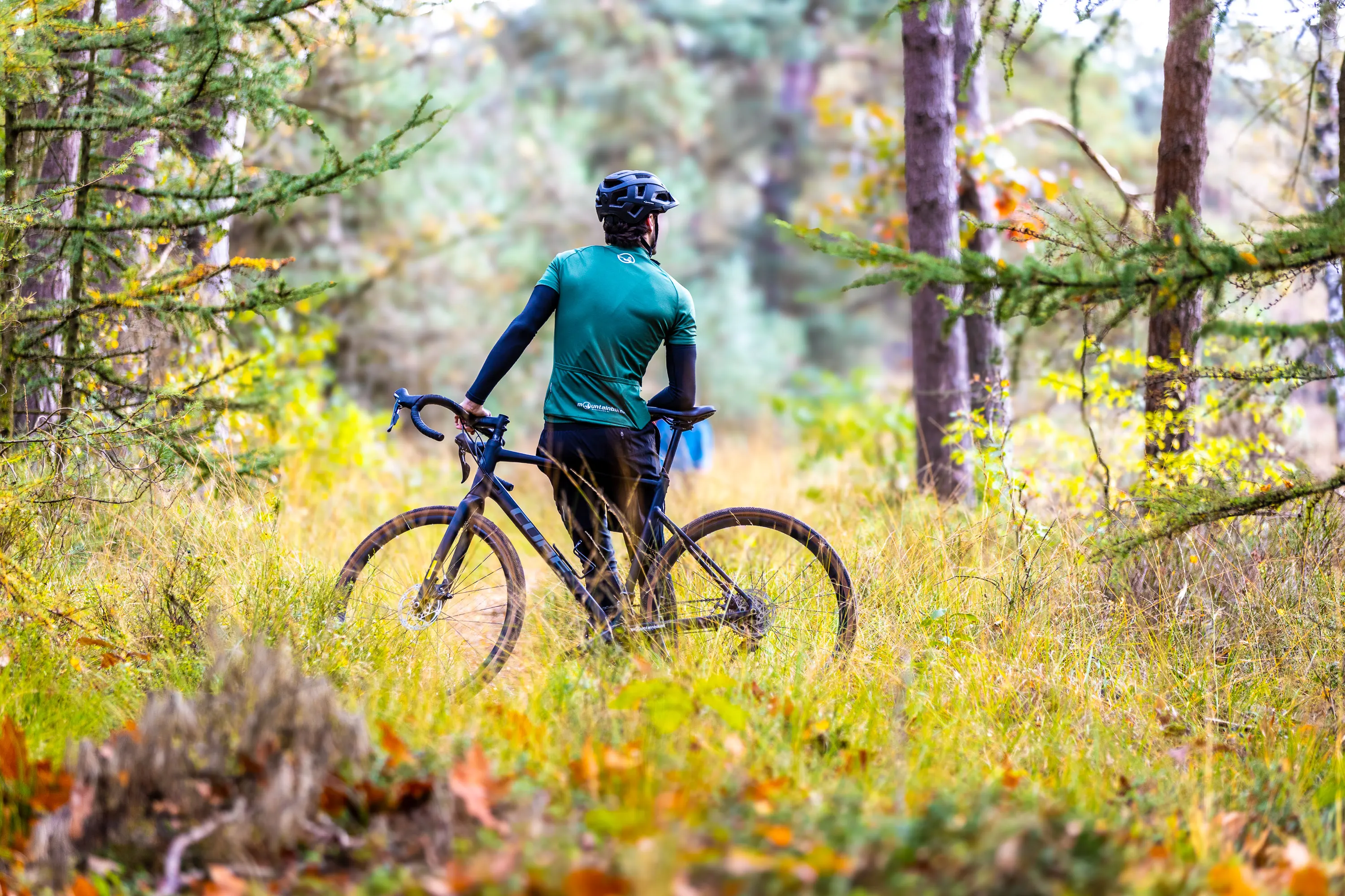 Een gravelbiker die naar de omgeving kijkt