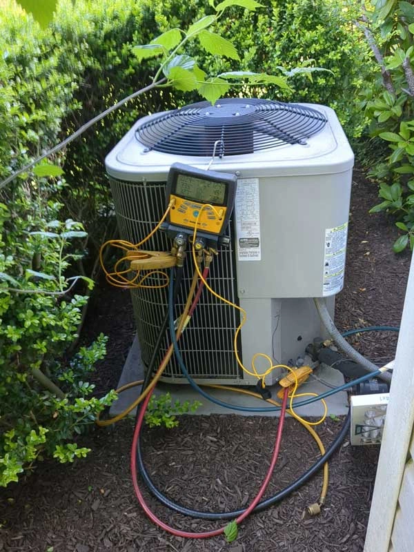 Air conditioner in Yardley, PA receiving seasonal tune-up service by Ray's Heating & Air.