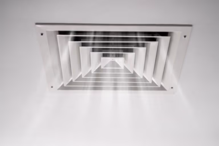 White ceiling vent with light streaming through it.