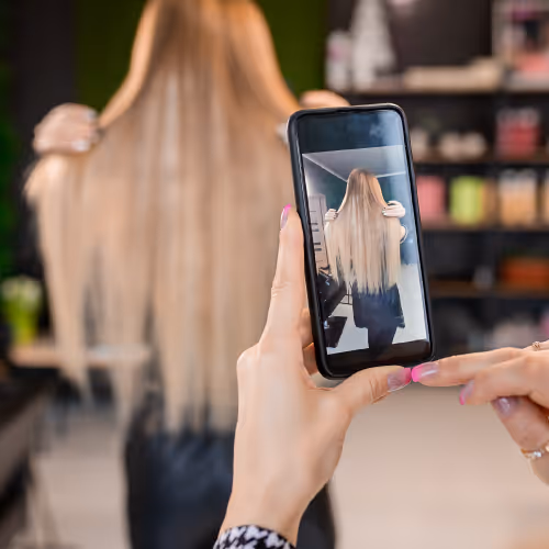 Friseur fotografiert Kundin nach Haarschnitt