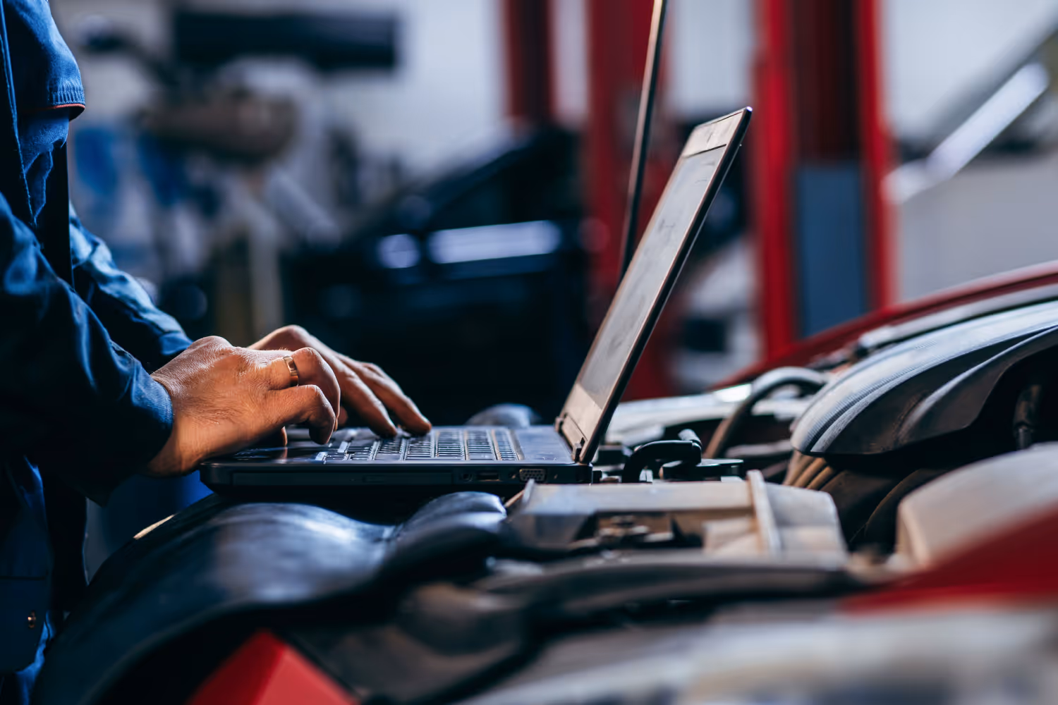 Aufgeklappter Laptop auf der Motorhaube eines Autos