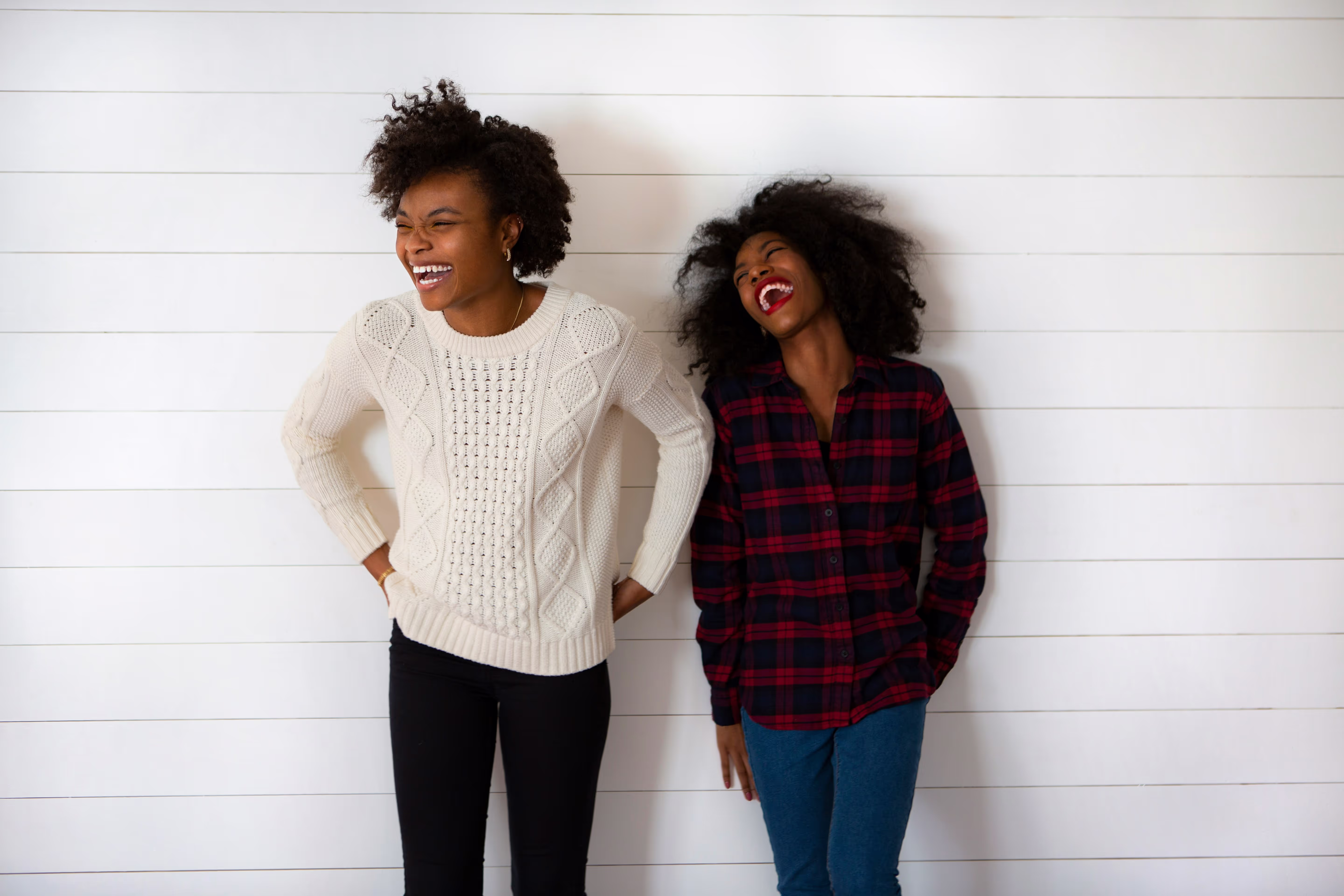 Deux consultantes en marketing et communication adossées à un mur blanc
