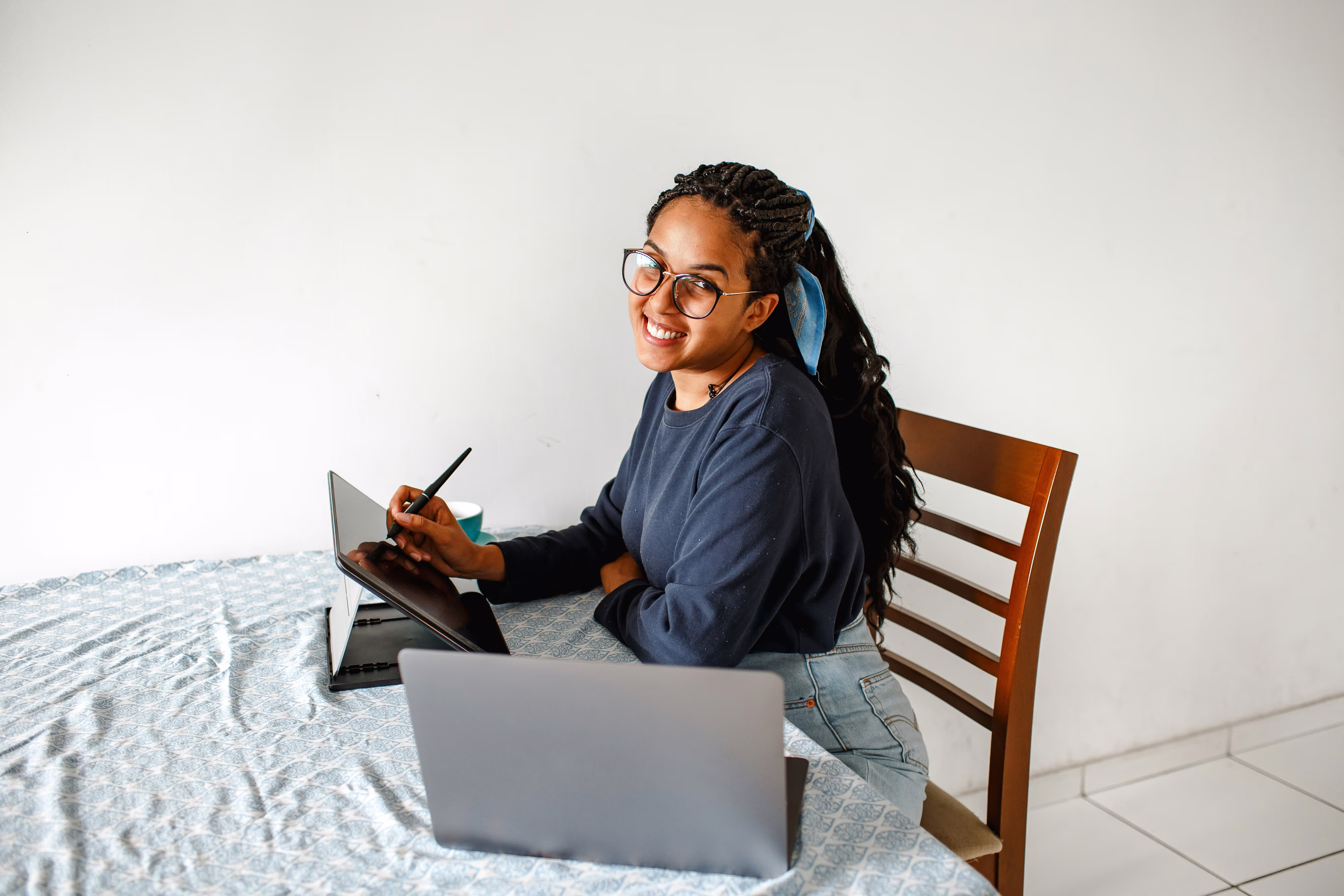 Femme micro-entrepreneuse travaillant sur tablette et ordinateur.