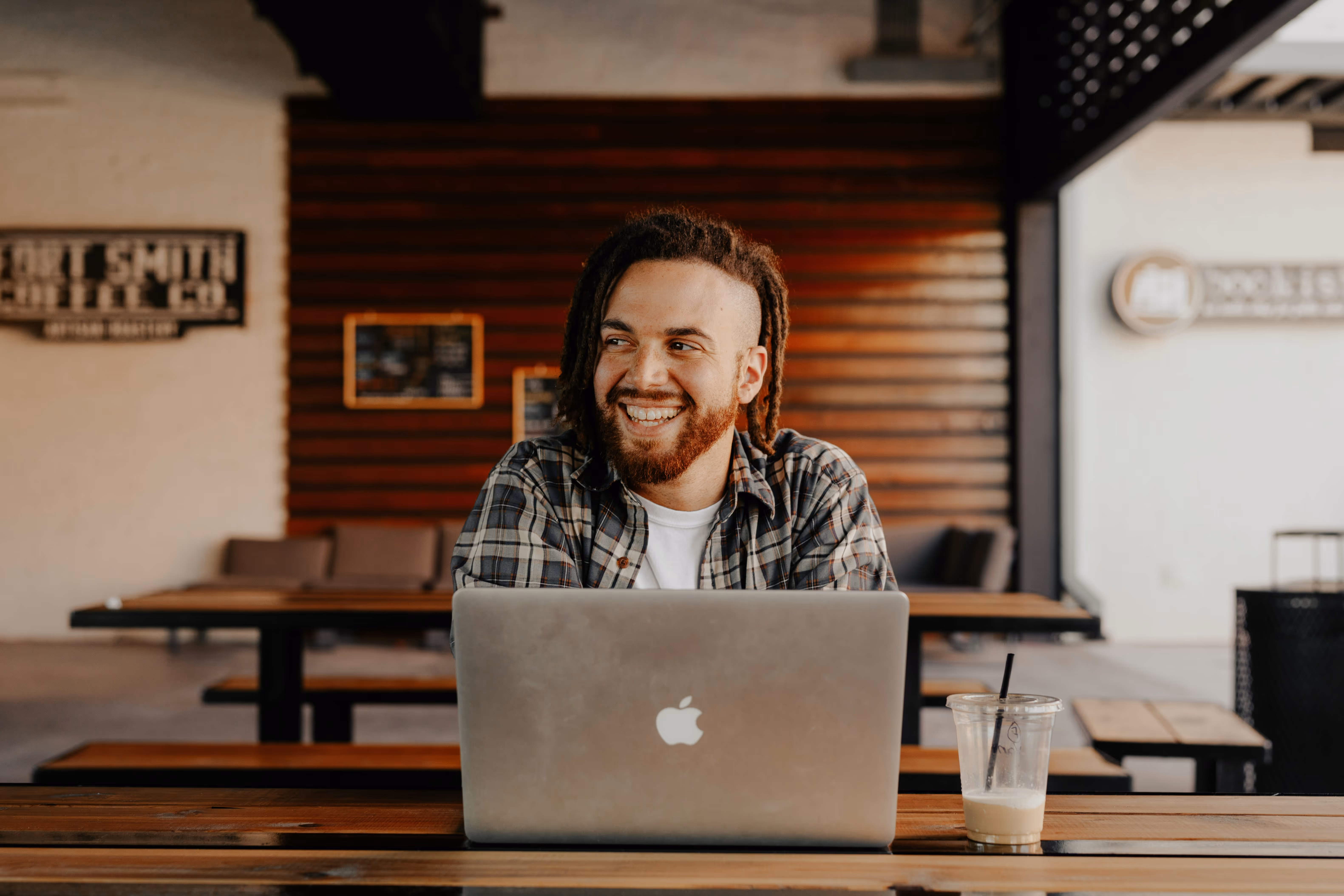 Développeur web ayant créé sa micro-entreprise avec Beliive entrain de télétravailler depuis un café à Paris.