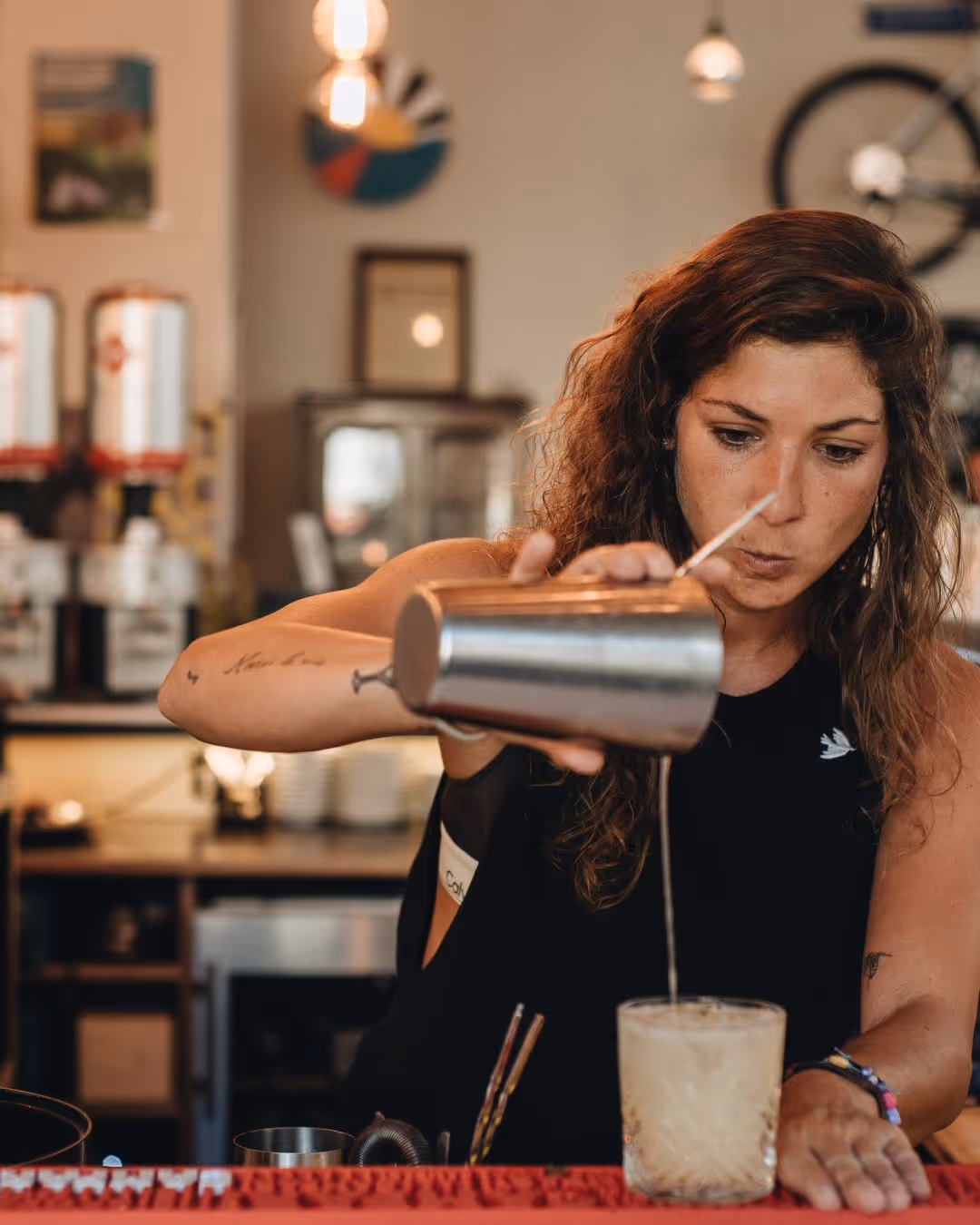 Jeune femme barista experte préparant un café dans un établissement chaleureux. Cette image illustre les opportunités d'emploi saisonnier dans la restauration et l'hôtellerie. Les jobs saisonniers de barista offrent une excellente expérience professionnelle dans le service client et la préparation de boissons. Trouvez votre travail saisonnier dans la restauration sur Ohmyseason.fr - secteur qui recrute massivement pendant les saisons touristiques.