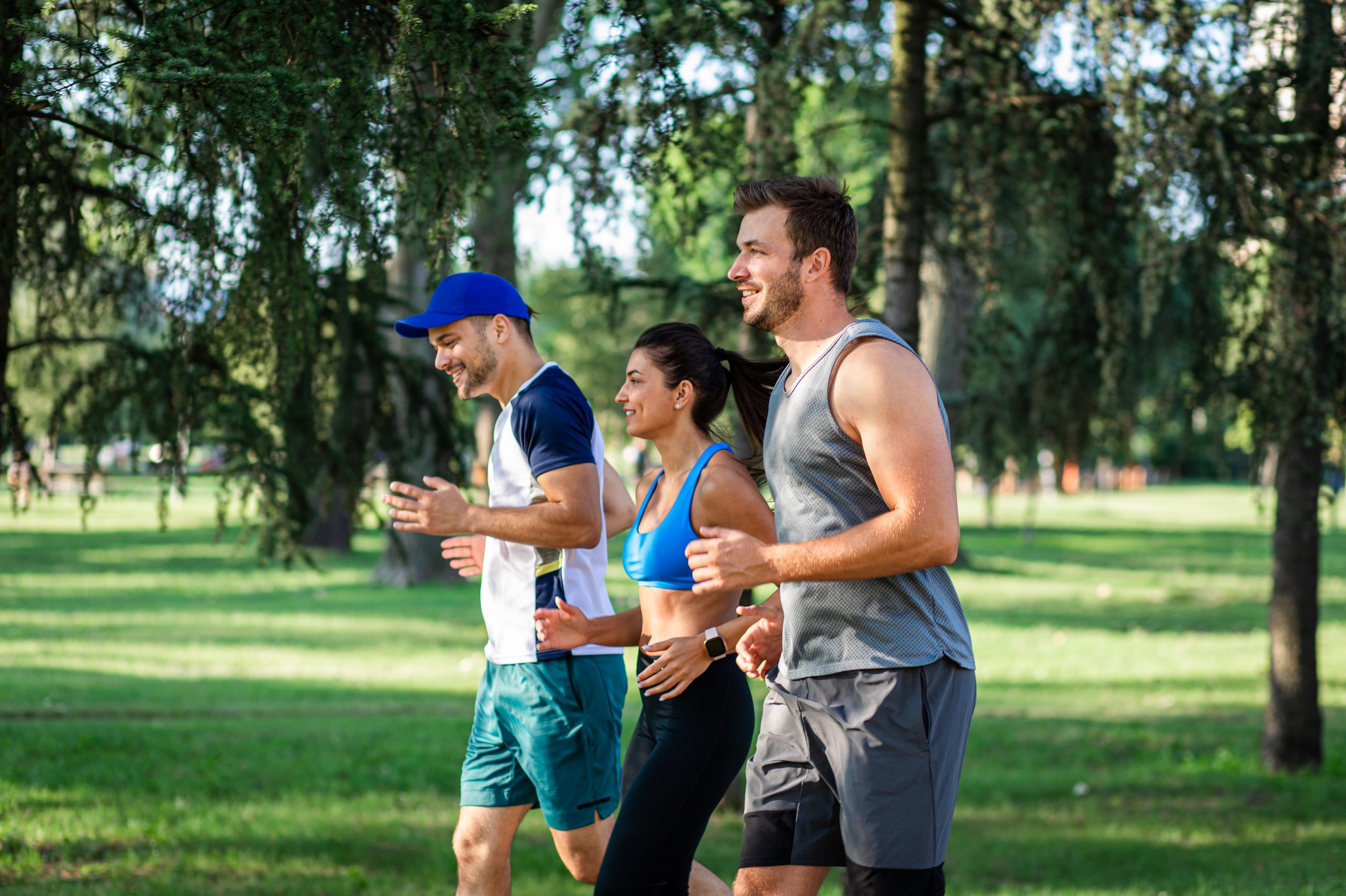 Gruppe von Menschen beim gemeinsamen Laufen im Park am frühen Morgen