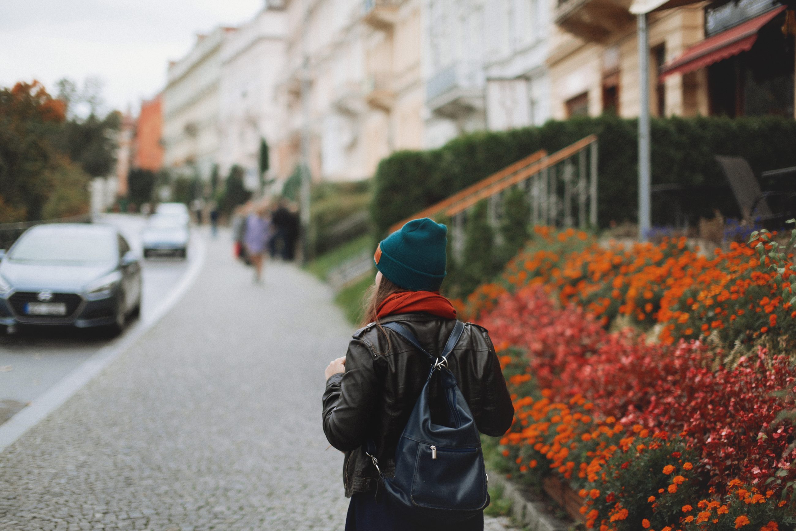 Frau geht spazieren durch eine herbstliche Straße als Symbol für Bewegung als Ausweg aus dem Functional Freeze