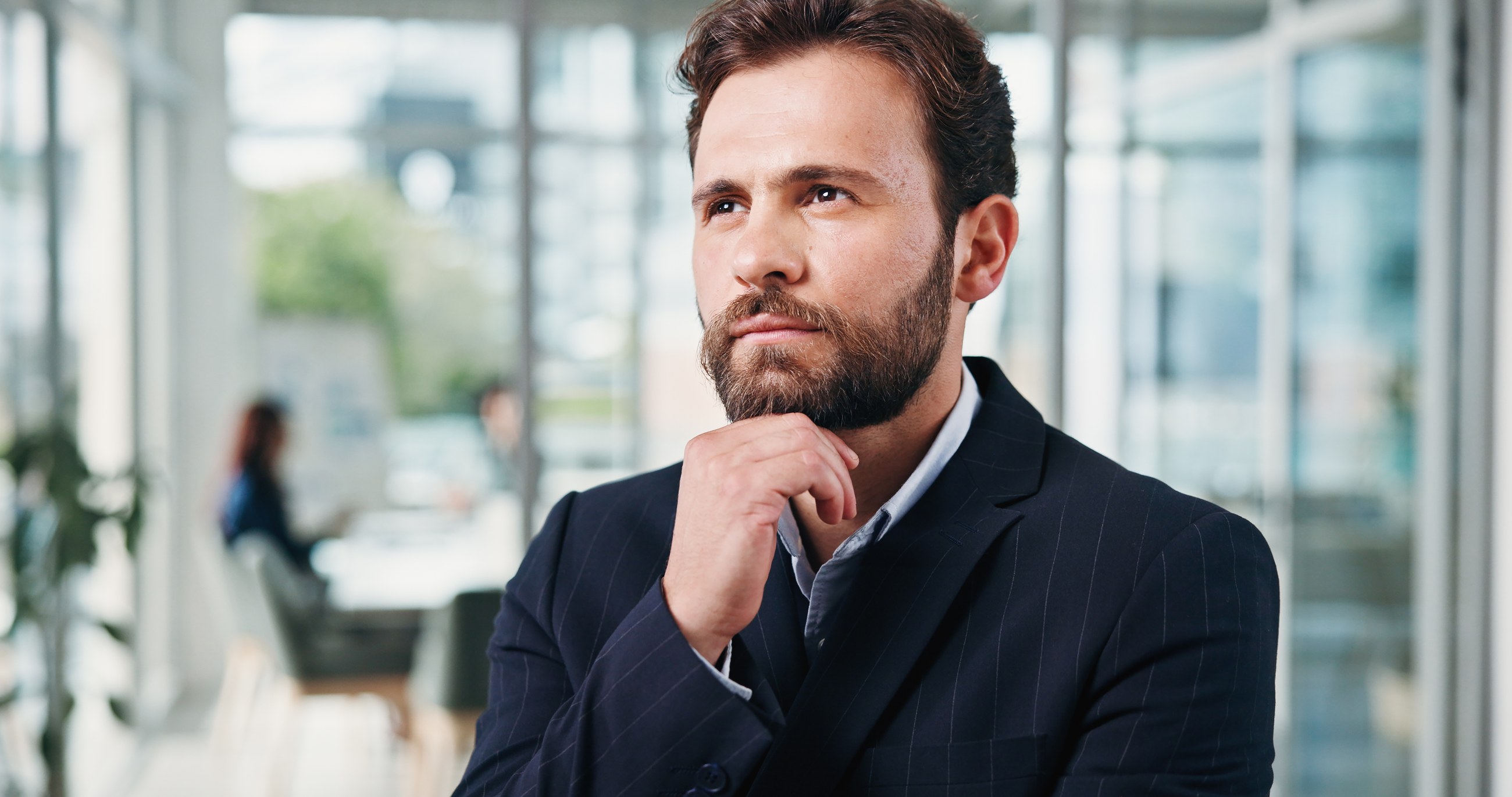 Nachdenklicher Manager im Büro, selbstsicher aber unsicher über seine Personalentscheidung