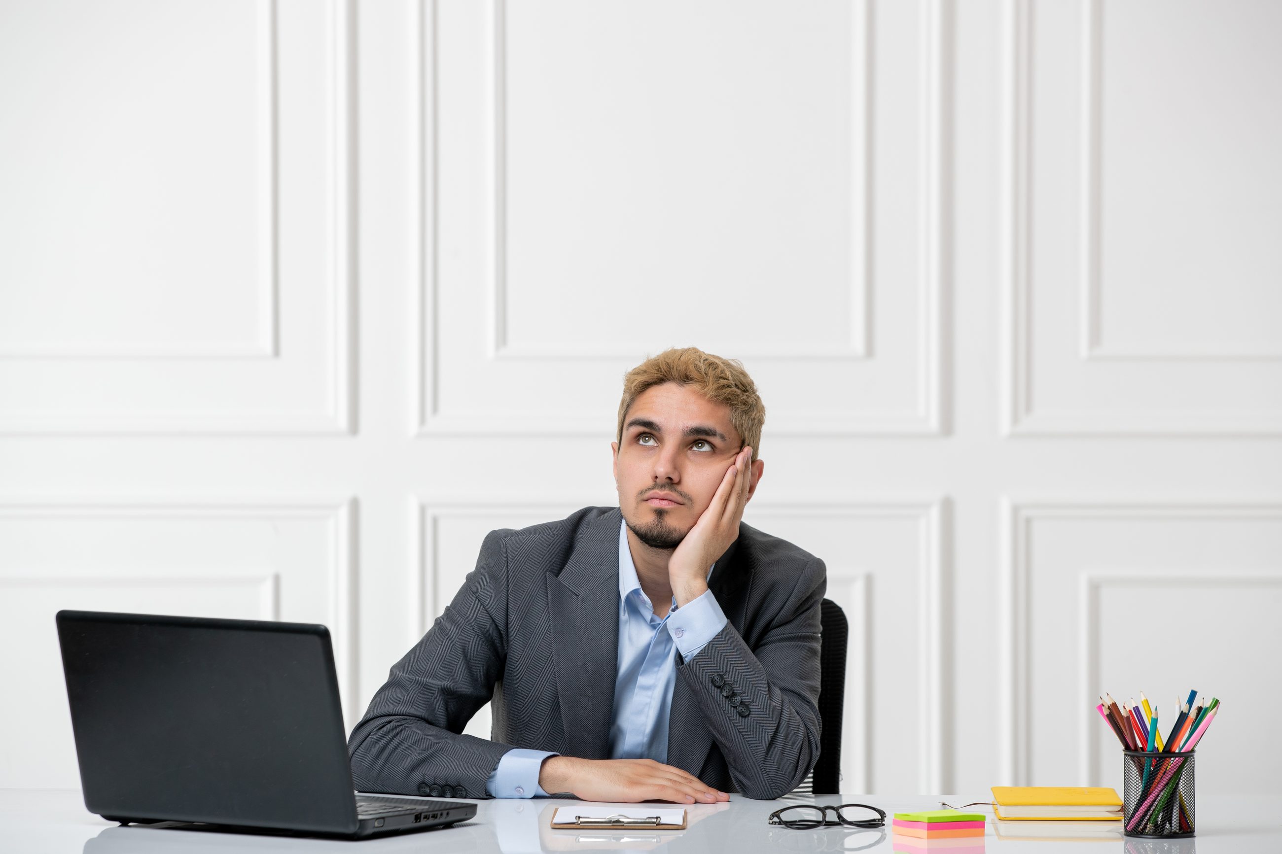 Nachdenklicher Mann am Schreibtisch im Büro, der eine Entscheidung hinterfragt