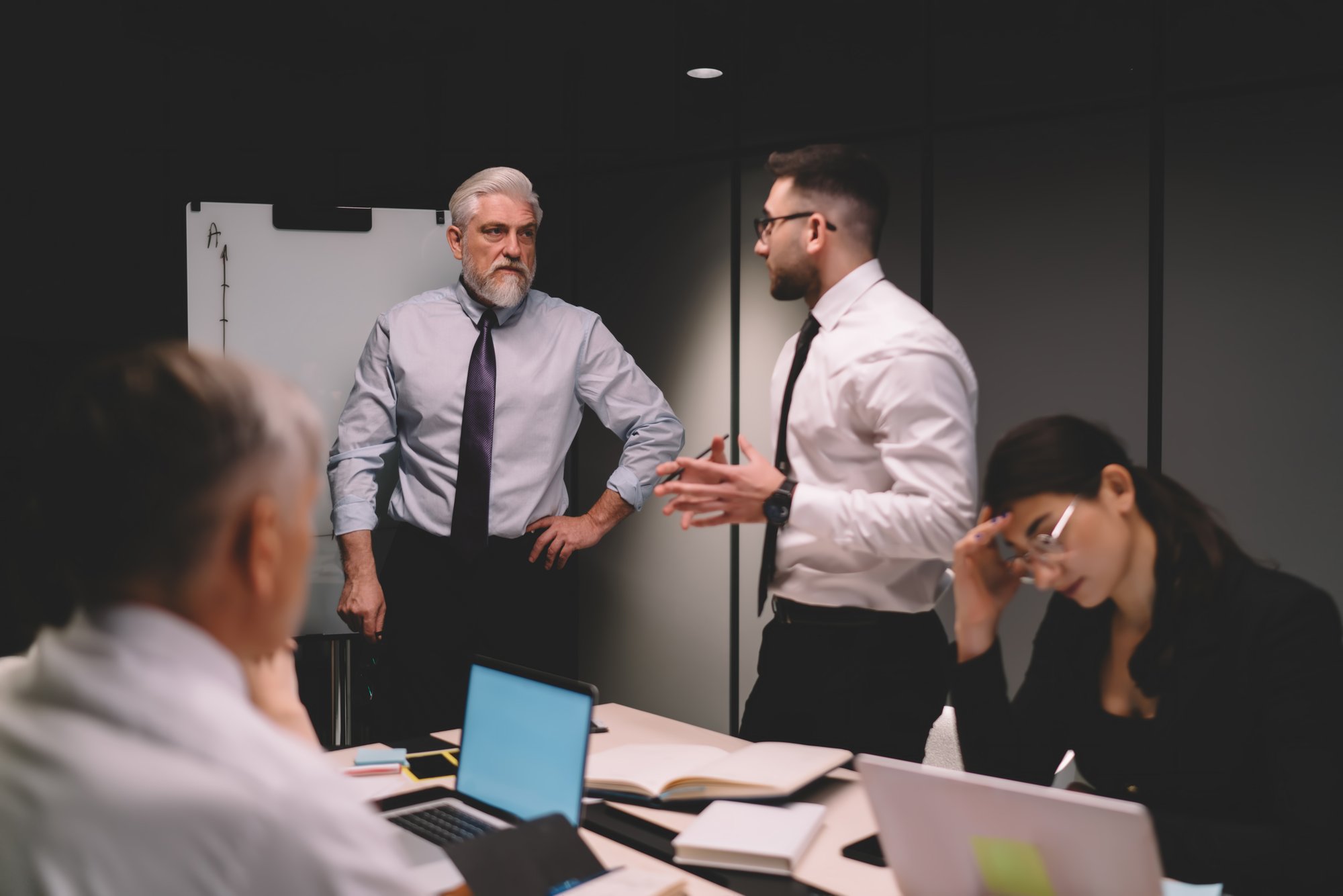 Team sitzt angespannt in einer Krisenbesprechung im Büro