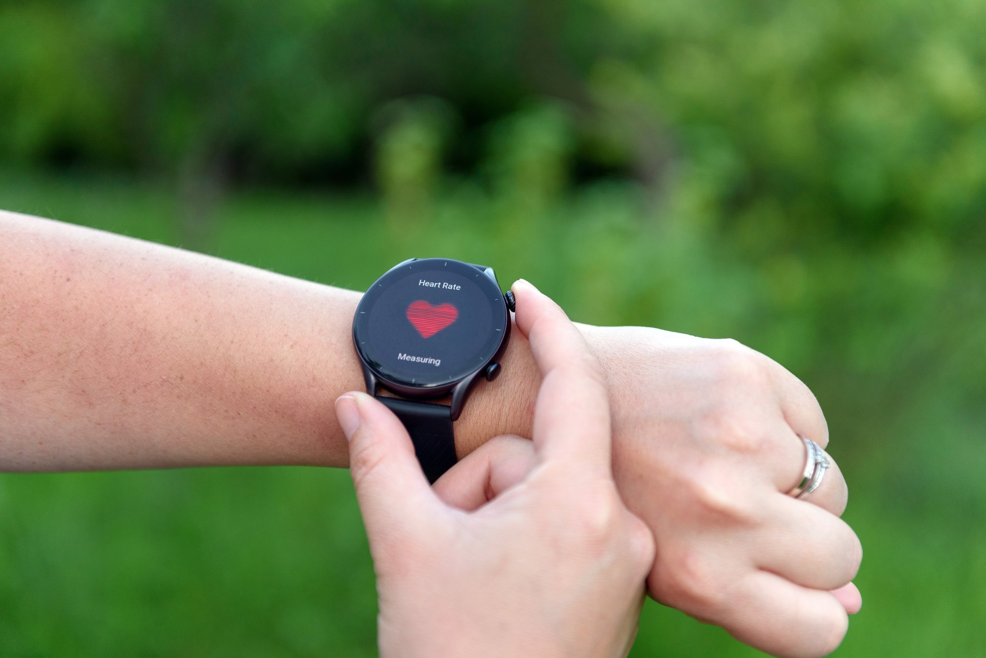 Person prüft die Herzfrequenz auf der Smartwatch im Freien