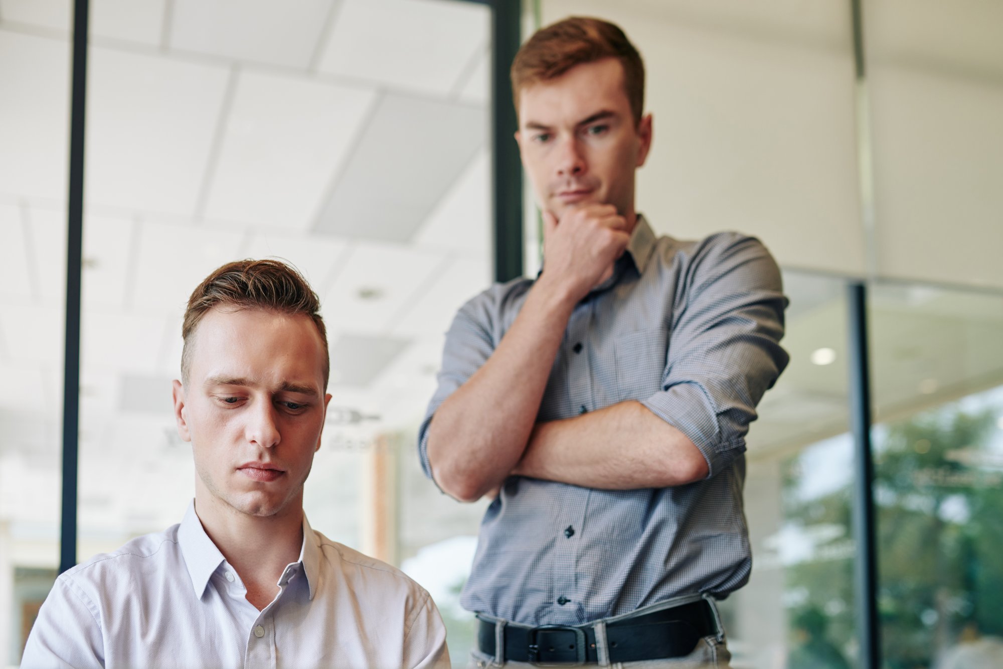 Führungskraft im ernsten Vier-Augen-Gespräch mit einem Mitarbeiter im Büro