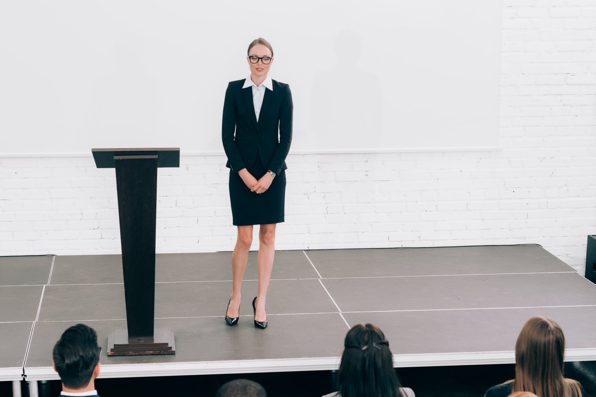 Frau hält souverän einen Vortrag vor Publikum im Konferenzraum