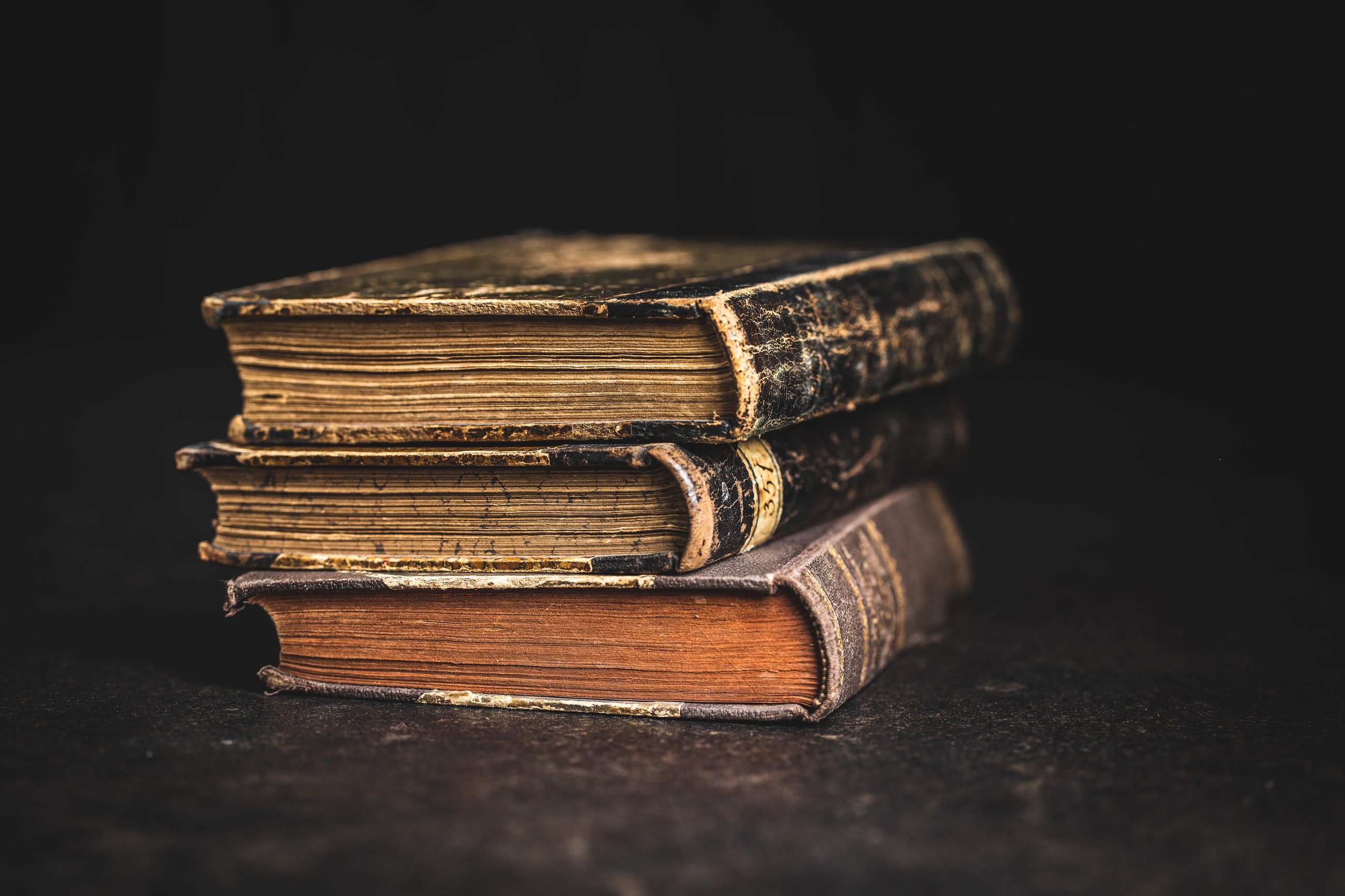 Stapel alter Bücher im warmen Licht als Sinnbild für Klassiker über Macht und Einfluss
