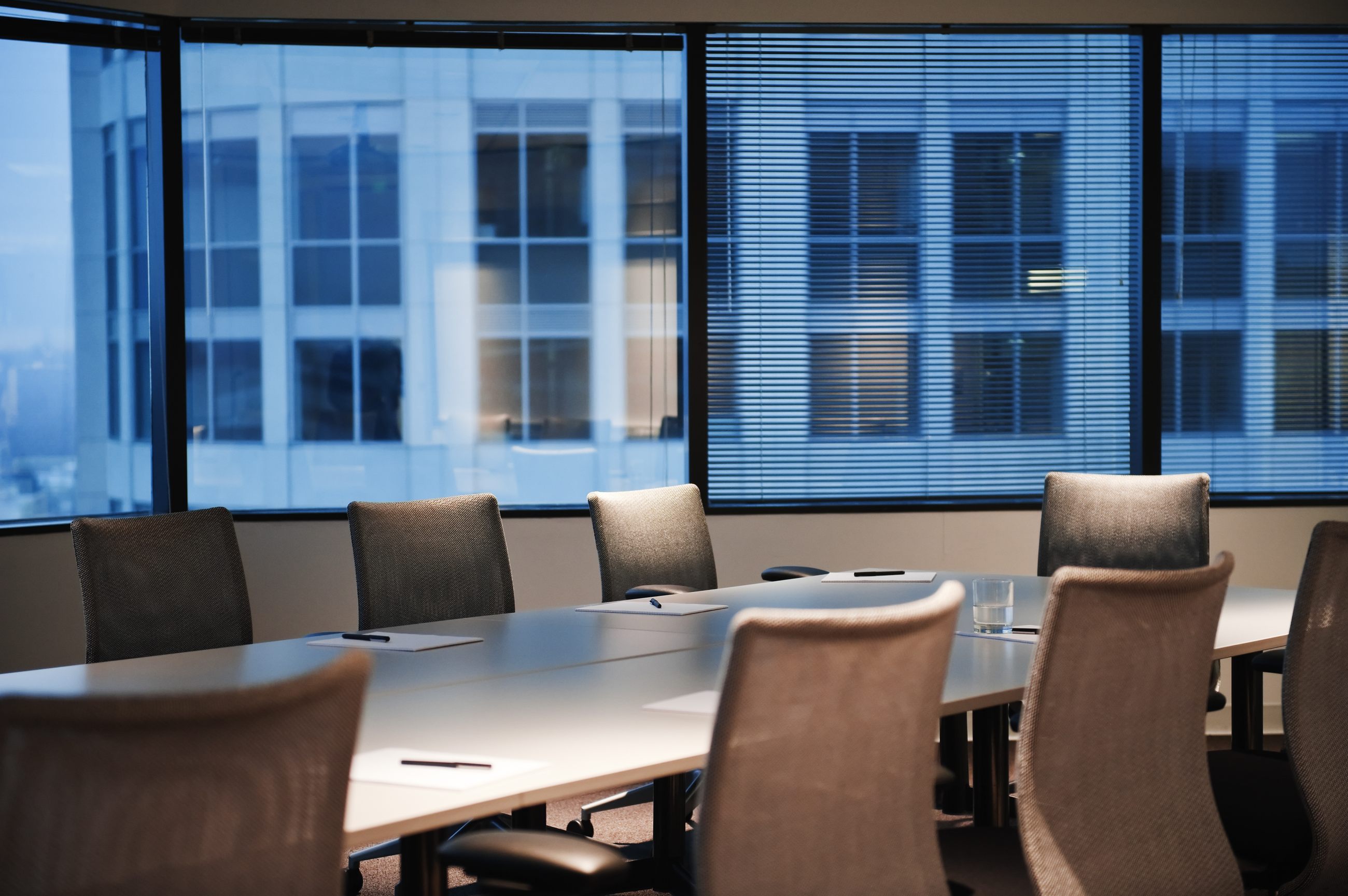 Leerer Konferenzraum mit Blick auf die Stadt im Abendlicht als Sinnbild für Zielvereinbarungen im Management