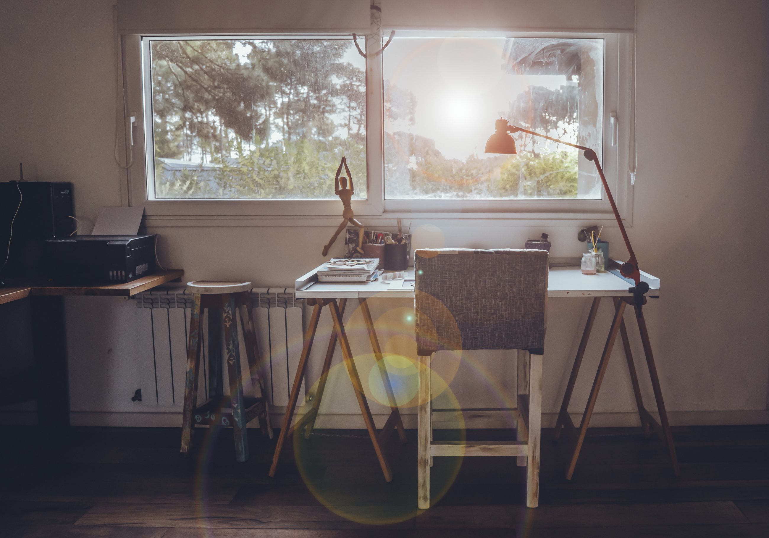 Schreibtisch am Fenster im Morgenlicht als Sinnbild für Motivation beim Arbeiten von zu Hause