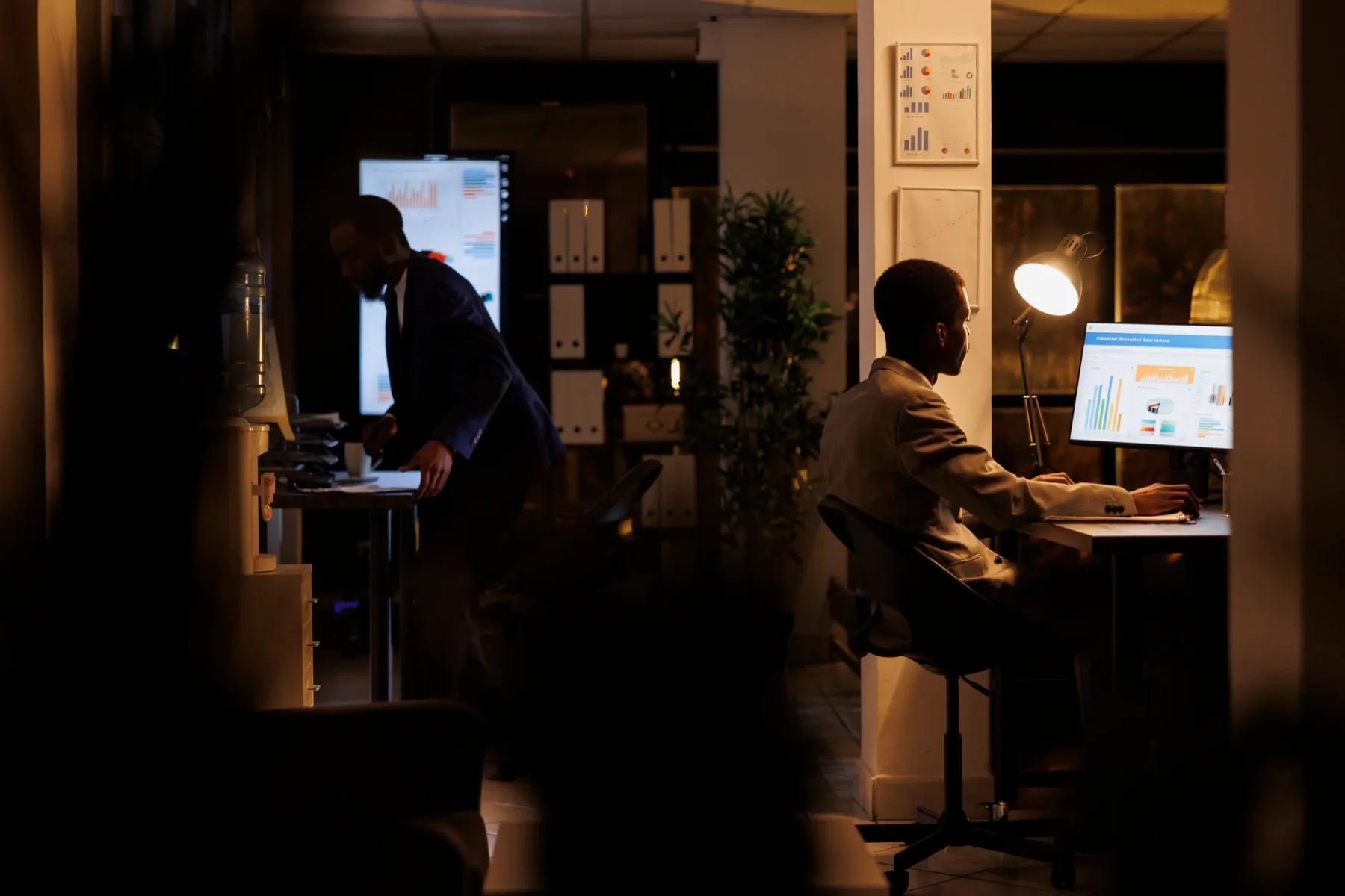 Manager arbeitet spätabends allein im dunklen Büro, Sinnbild für den Antreiber Streng dich an